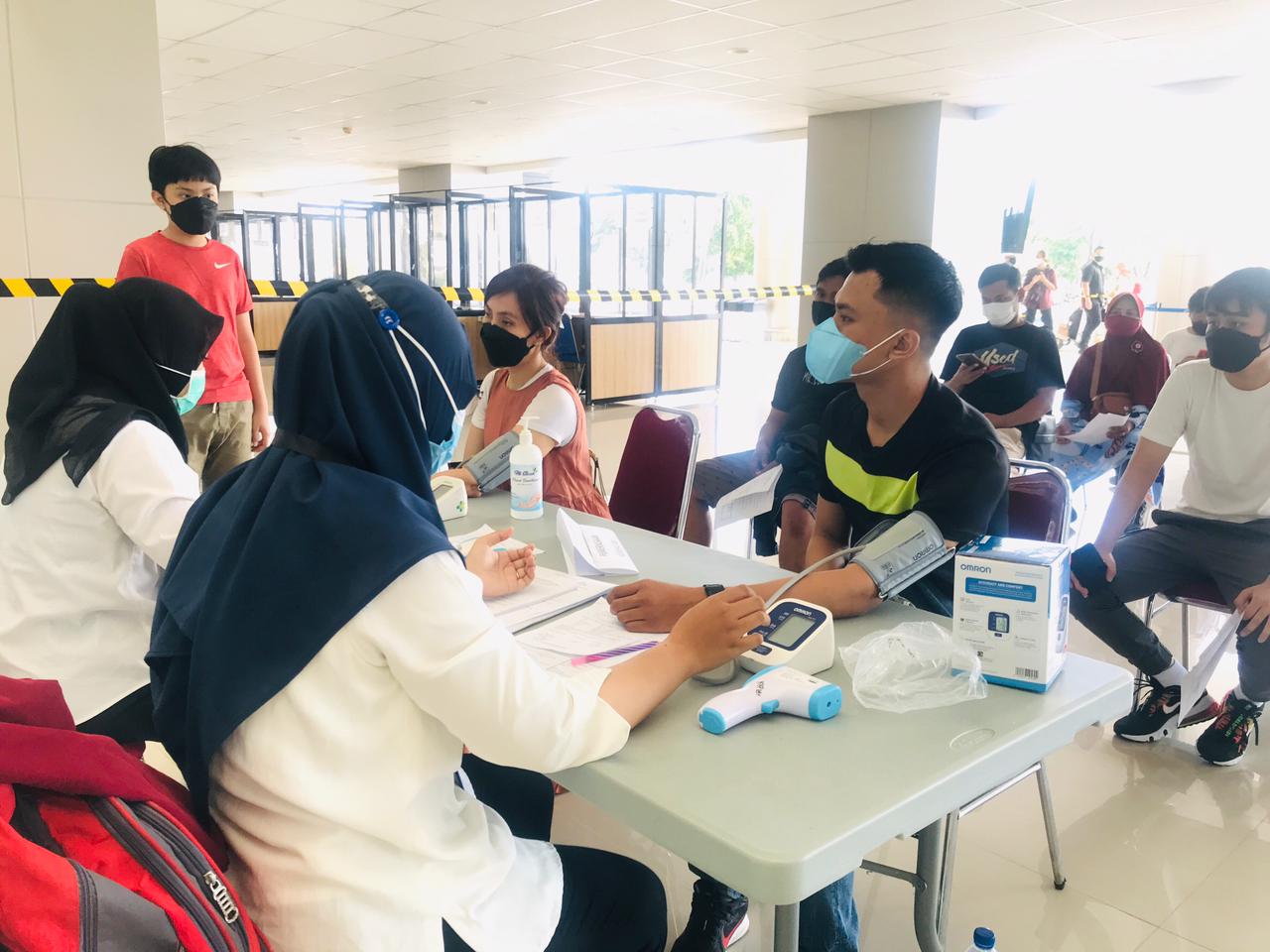 Ilustrasi: Petugas kesehatan memeriksa kondisi penumpang pesawat yang akan melakukan vaksinasi