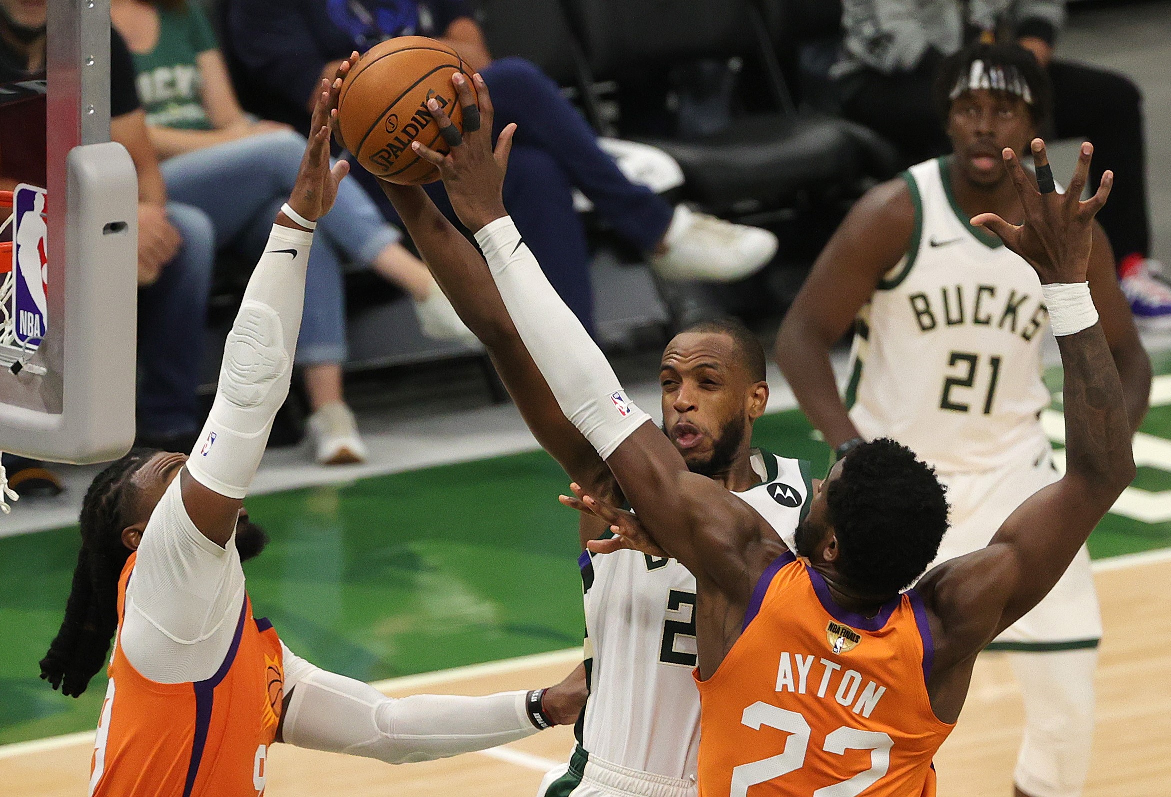 Pemain Milwaukee Bucks Khris Middleton berusaha mencetak poin melewati dua pemain Phoenix Suns di Gim 4 Final NBA.