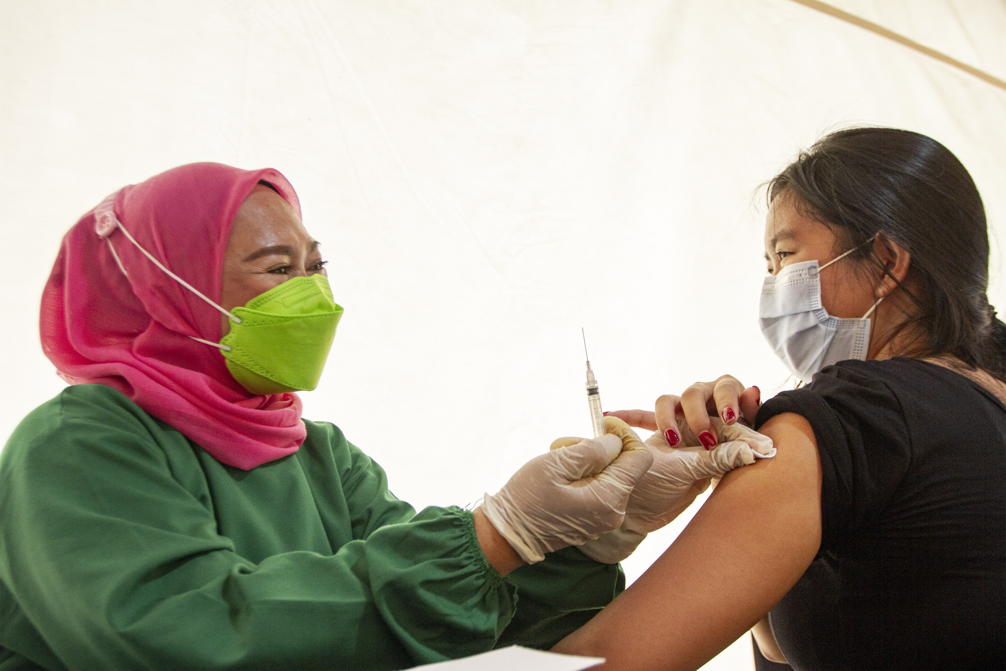 Petugas kesehatan menyuntikkan vaksin covid-19 saat vaksinasi massal di Stadion Singaperbangsa, Karawang, Jawa Barat, Sabtu (24/7/2021)