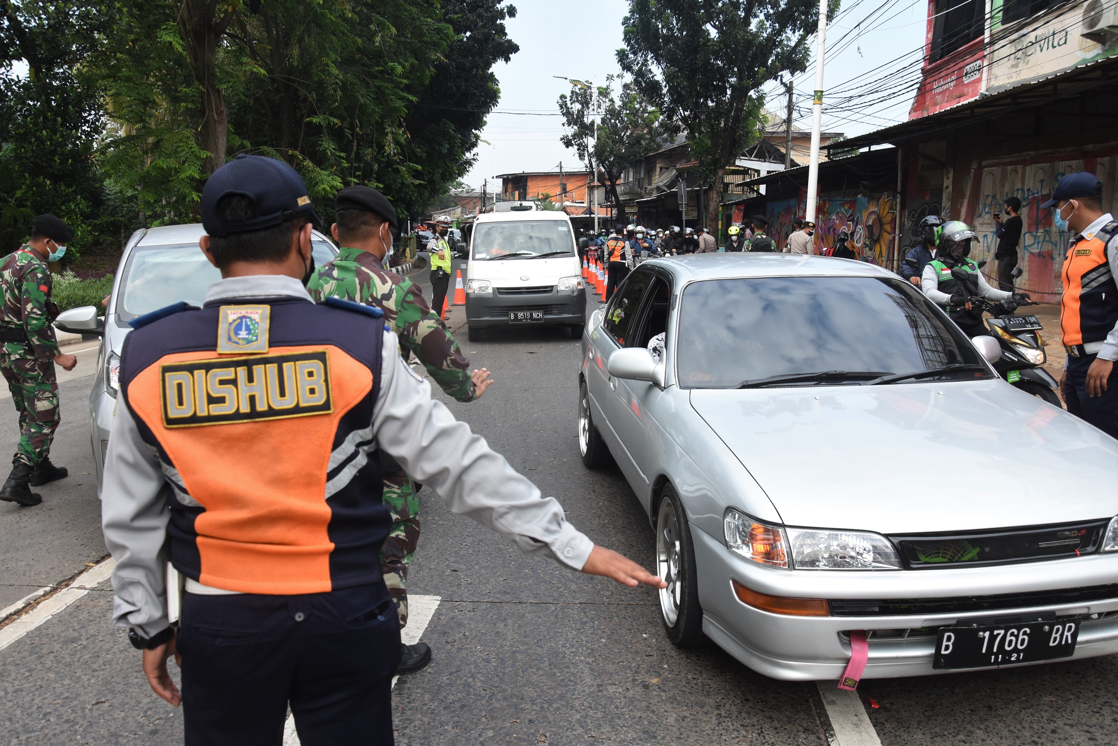 Petugas memeriksa STRP milik pengendara di pos penyekatan saat PPKM Darurat, Jalan Raya Lenteng Agung, Jakarta.