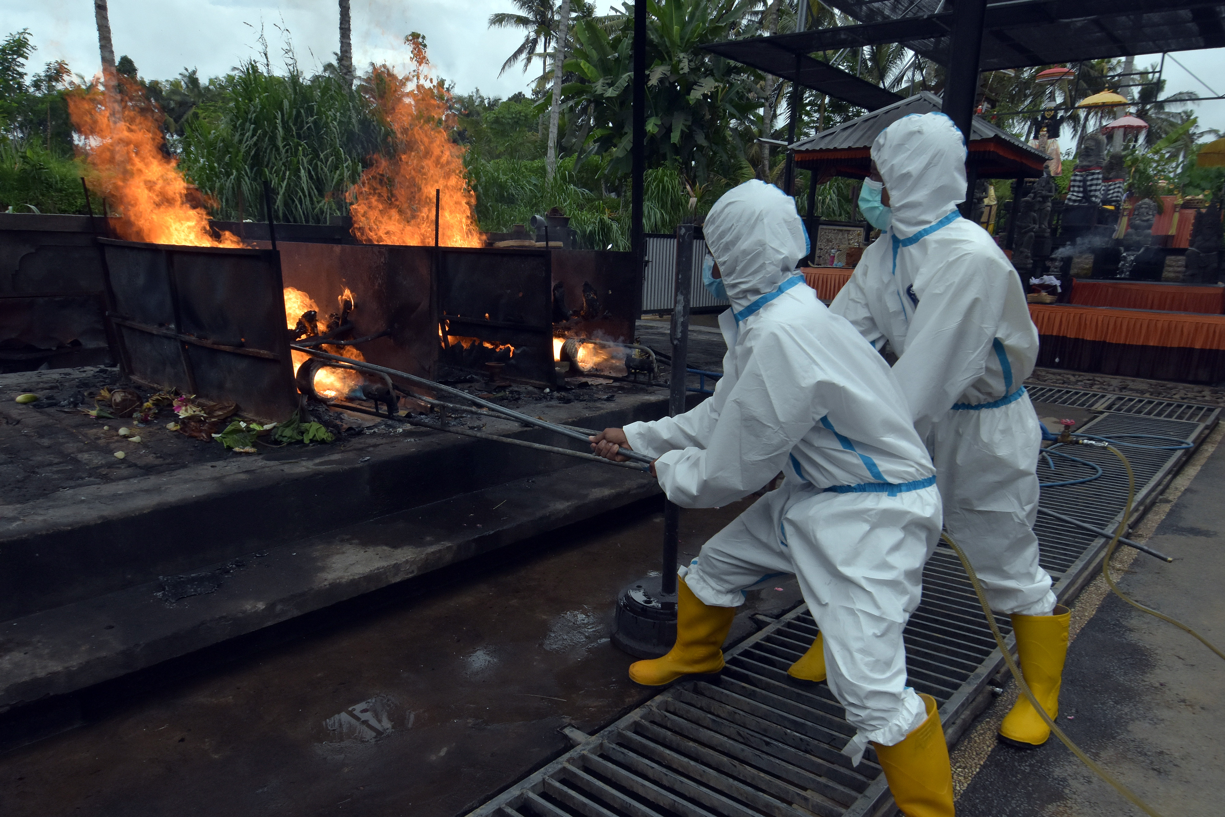 Ilustrasi petugas dengan APD lengkap melakukan kremasi jenazah pasien covid-19.