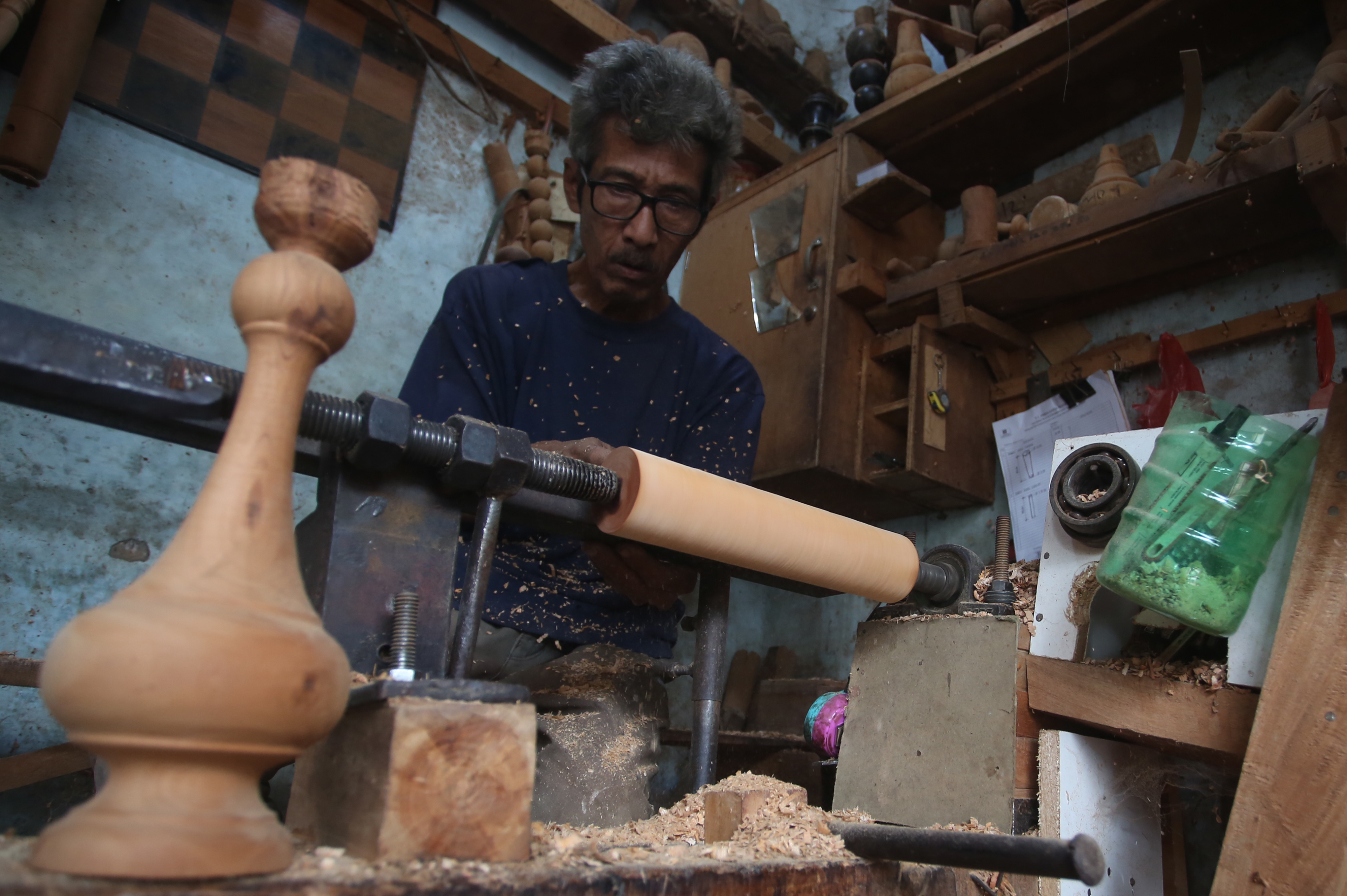 Perajin UMKM membentuk kayu di bengkel bubut kayu, Bambu Apus, Tangerang Selatan, Banten, Kamis (8/7/2021)