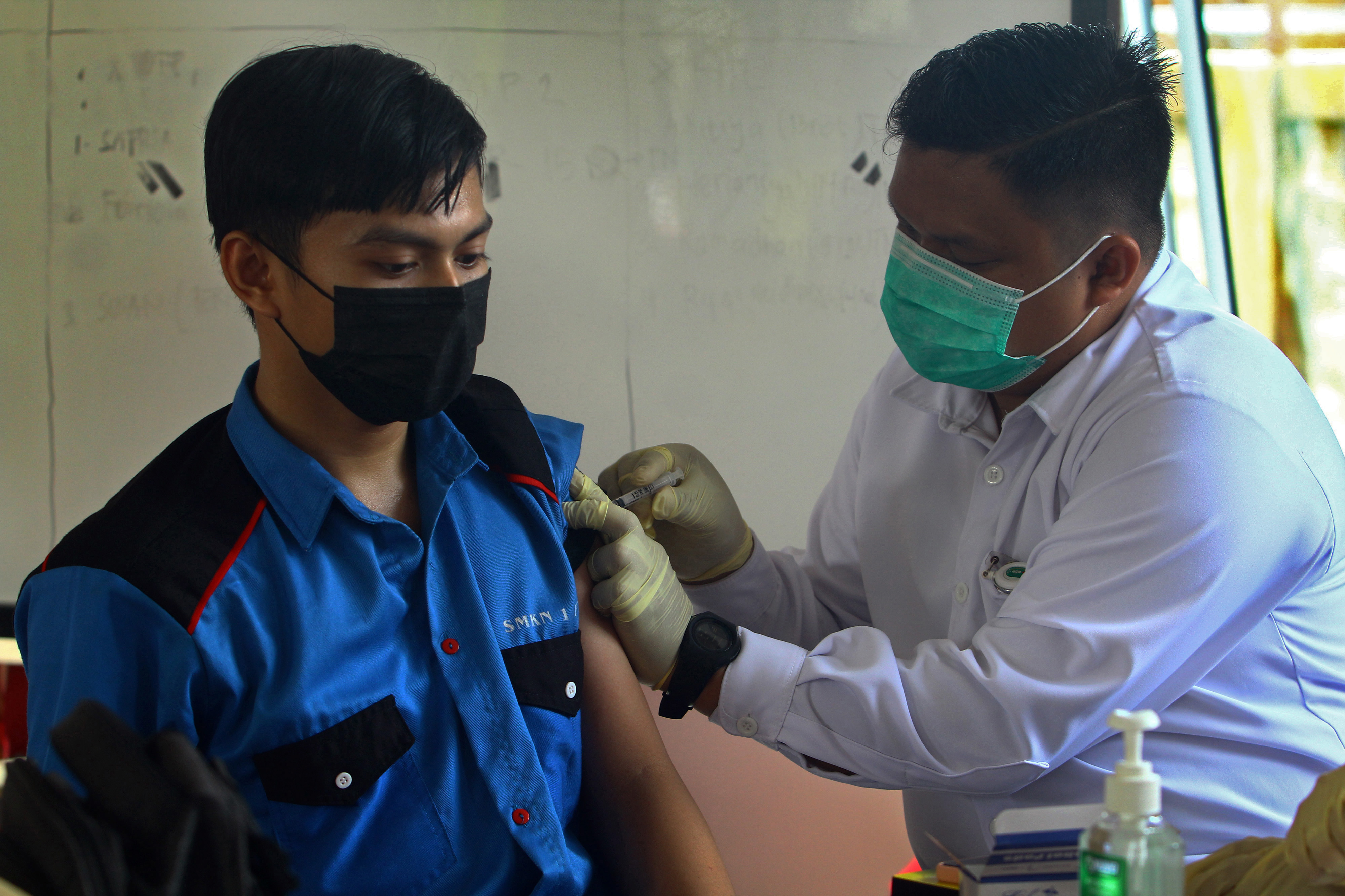 Petugas menyuntikkan vaksin covid-19 pada pelajar SMKN 1 di Pontianak, Kalimantan Barat, Rabu (7/7/2021).
