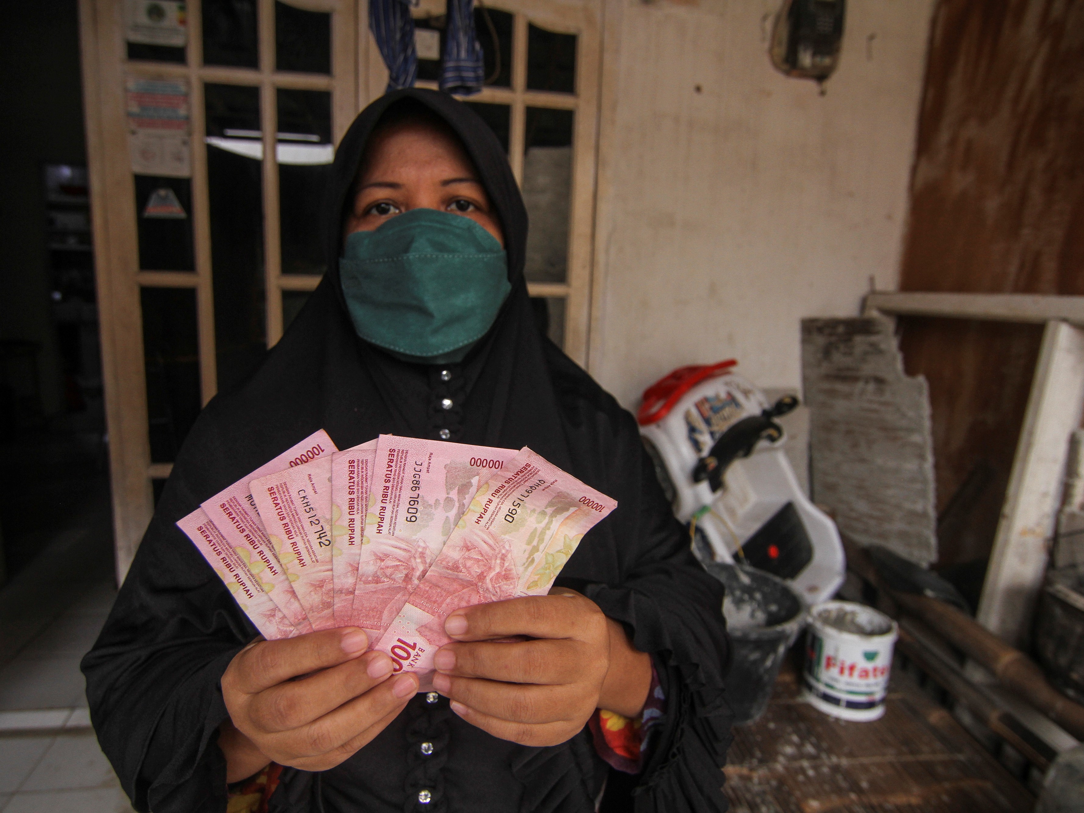 Warga menunjukkan uang Bantuan Sosial Tunai (BST) Kemensos di wilayah Bojong Pondok Terong, Depok, Jawa Barat, Kamis (22/7).