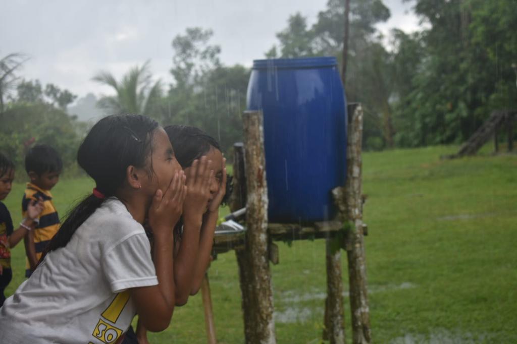 Anak-anak menikmati air yang sebelum sulit didapatkan di Desa Binusan Dalam, Nunukan, Kalimantan Utara.