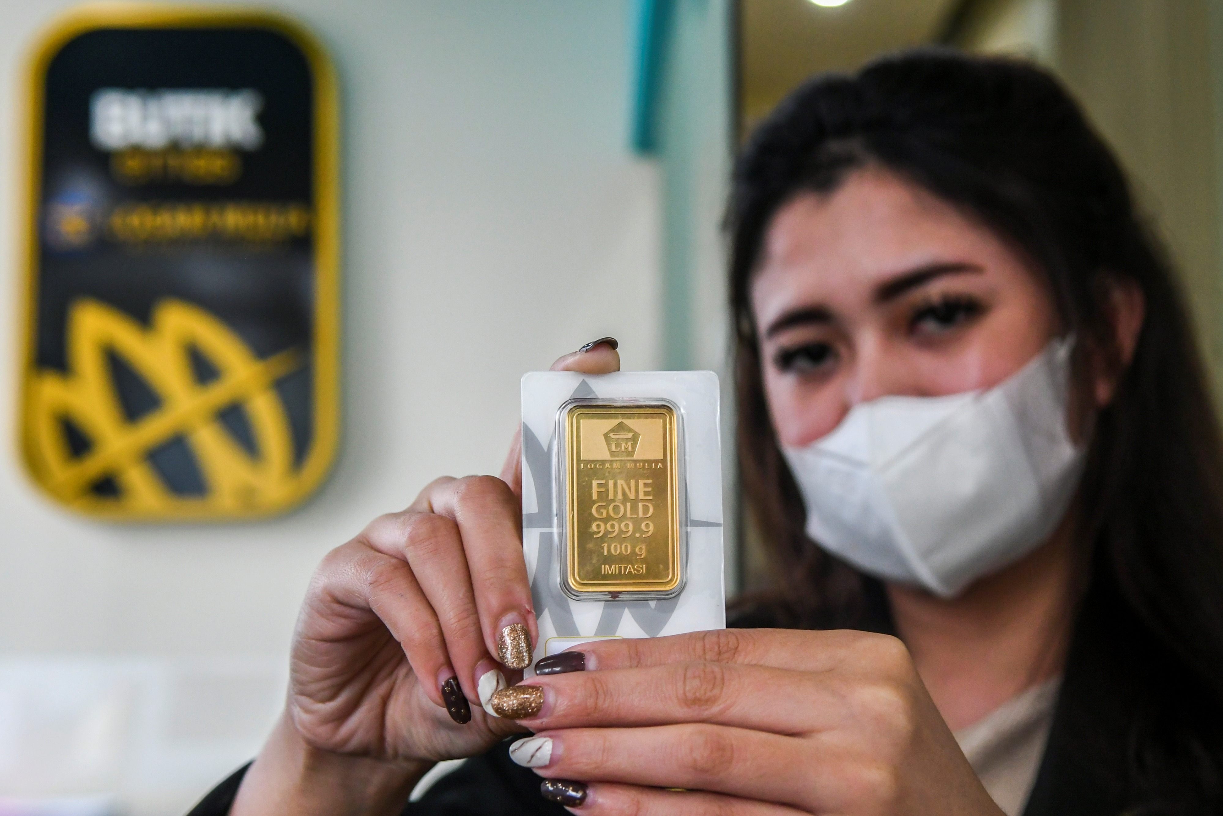 Karyawan menunjukkan emas batangan di Butik Emas Antam, Kebon Sirih, Jakarta, Senin (18/1).