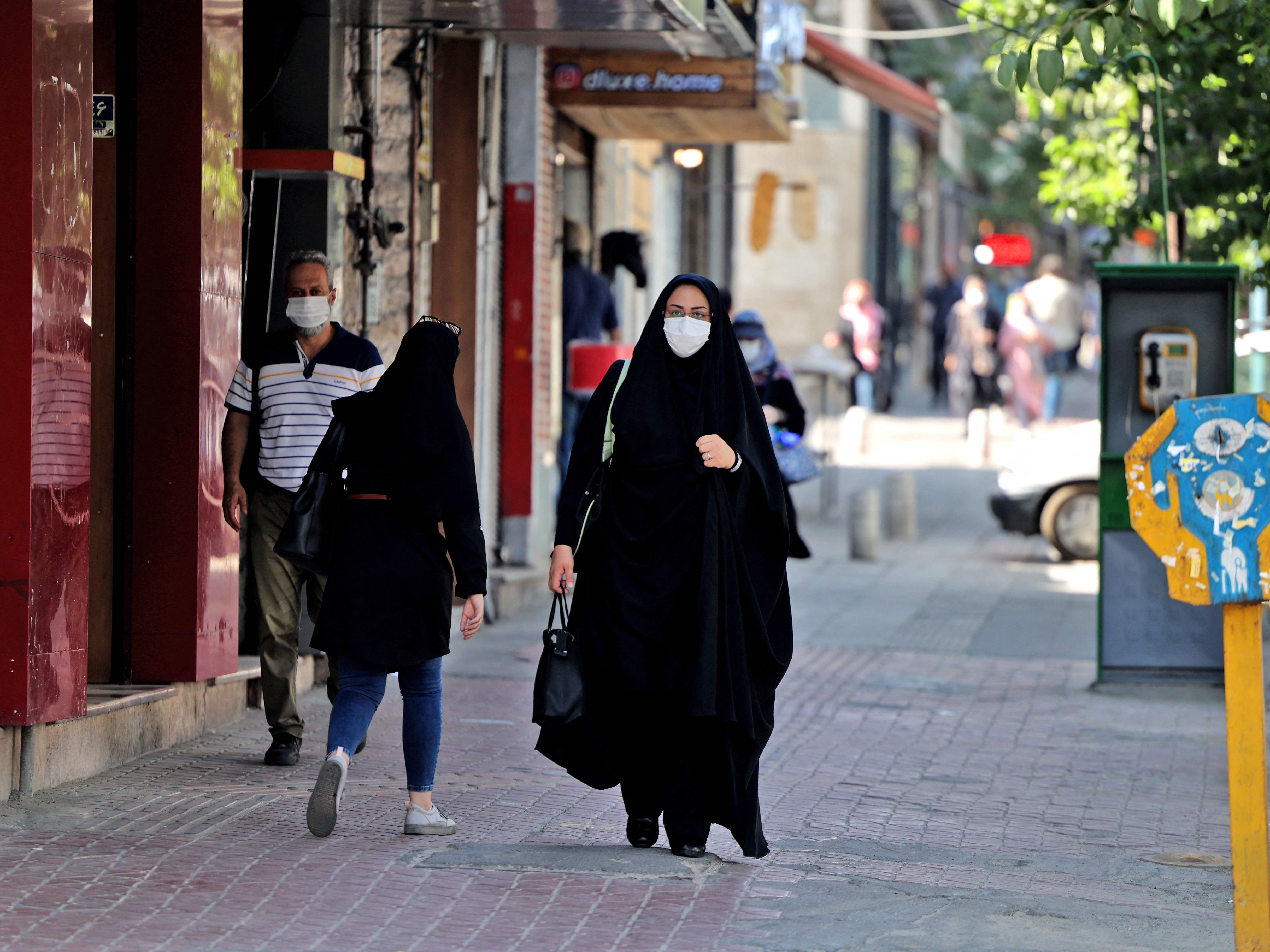 Warga Iran memakai masker sebagai tindakan pencegahan covid-19 di suatu jalan di ibu kota Teheran, pada 7 Juli 2021.