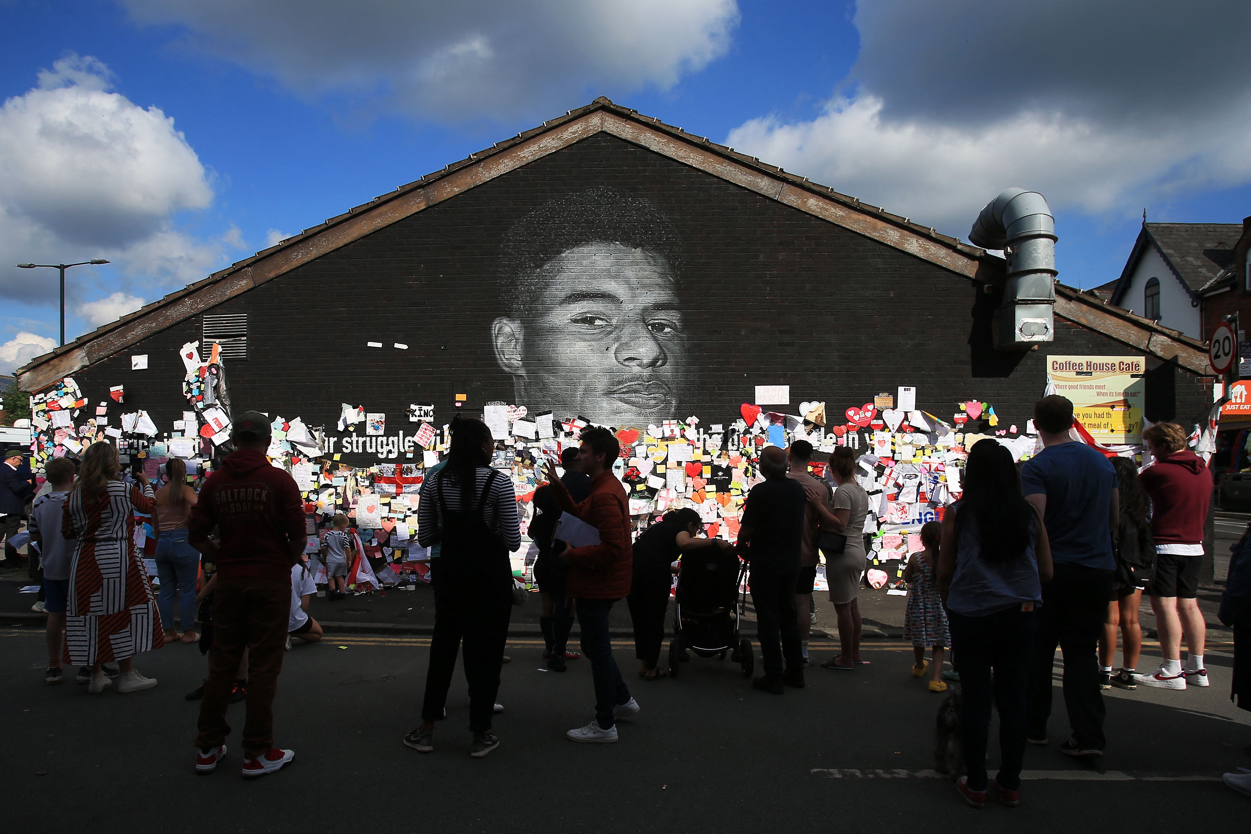 Demonstran antirasisme berkumpul di depan mural Marcus Rashford yang dirusak di Manchester.