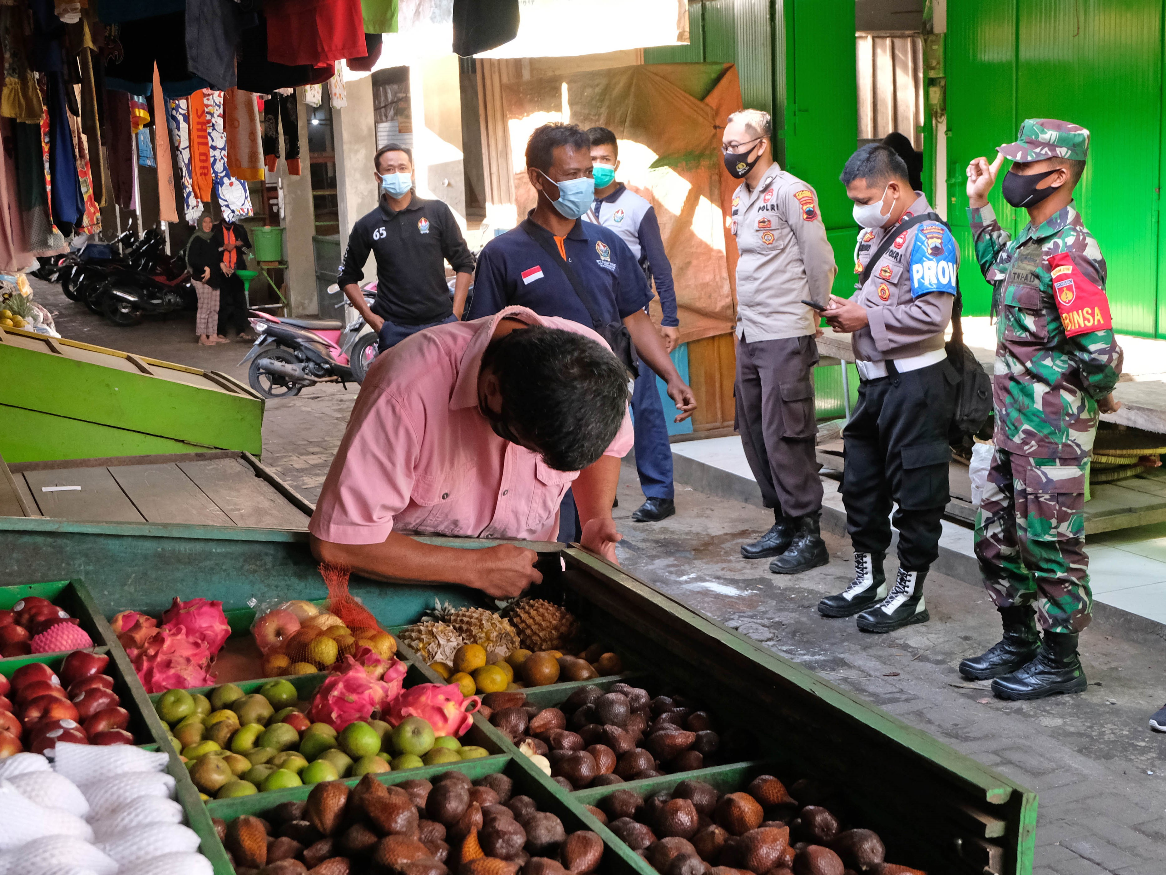 Petugas gabungan mengimbau pedagang menutup kios saat penerapan jam operasional PPKM Darurat di pasar Adiwinangoen Ngadirejo, Temanggung. 