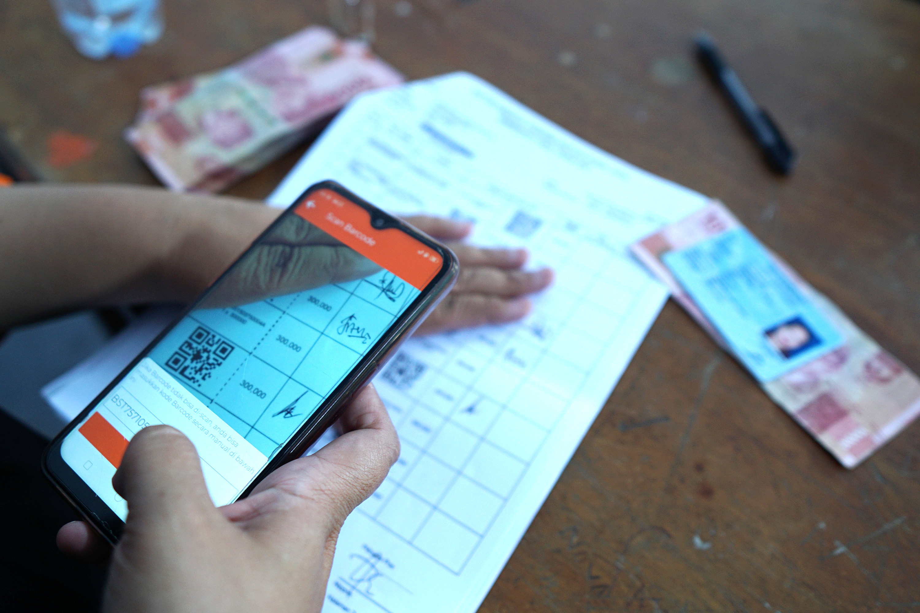 Petugas memindai data warga yang akan menerima Bantuan Sosial tunai (BST)