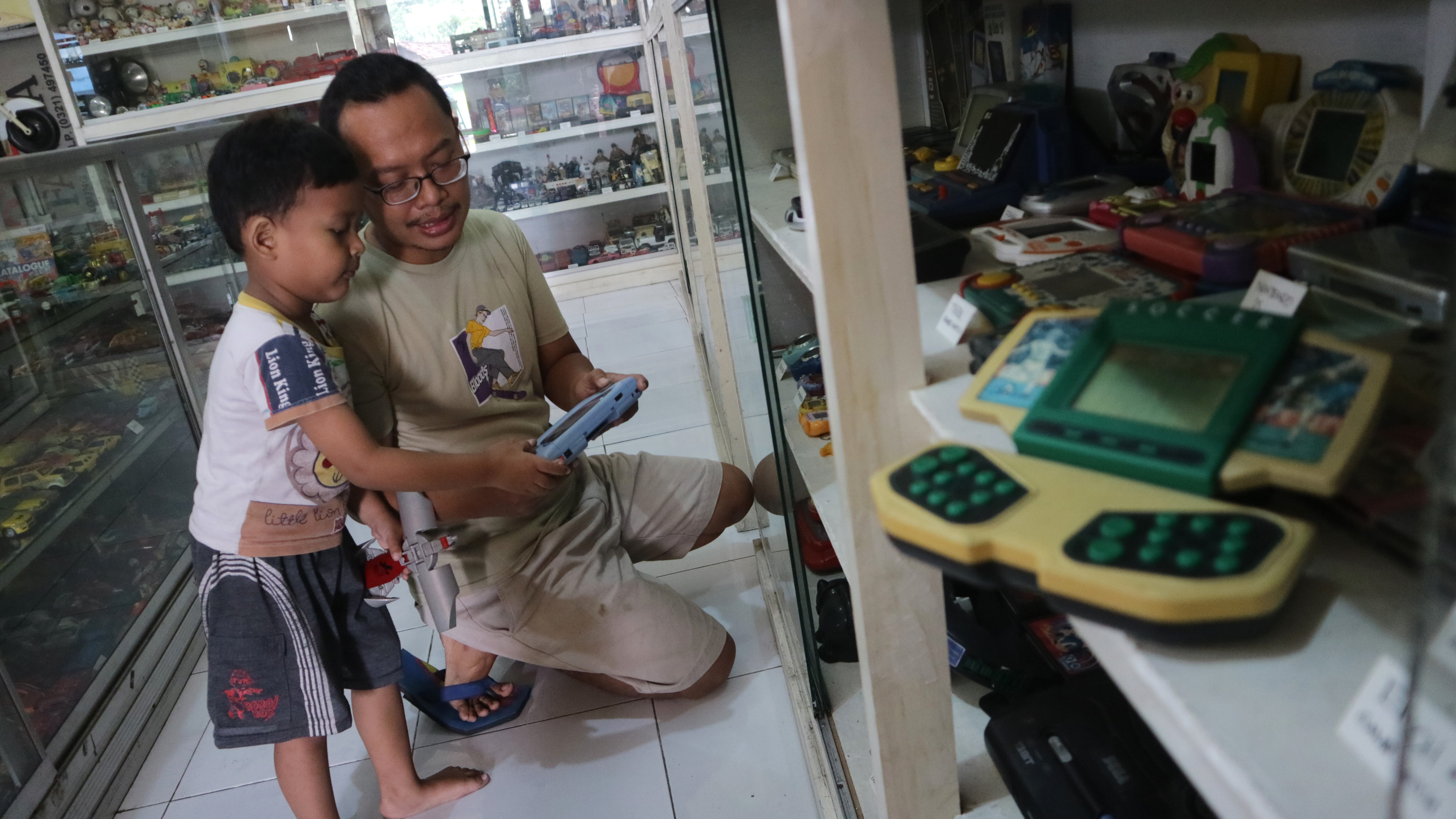 Foto ilustrasi -Endra Koestanto menunjukkan pada anaknya mainan 'game watch' koleksinya.