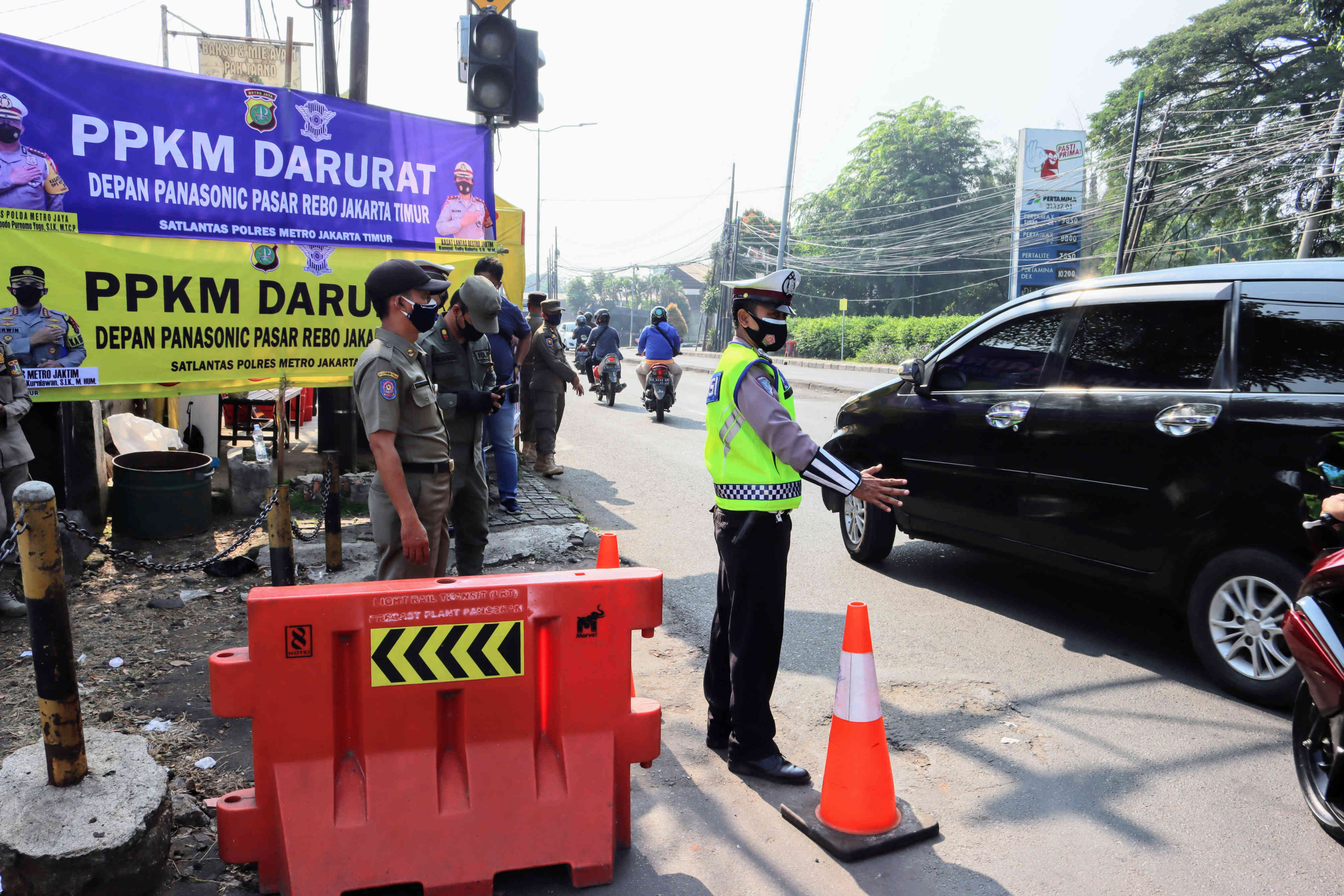  Petugas kepolisian mengatur arus lalulintas dalam rangka PPKM Darurat di di Jalan Raya Bogor, Jakarta, Sabtu (3/7/2021).