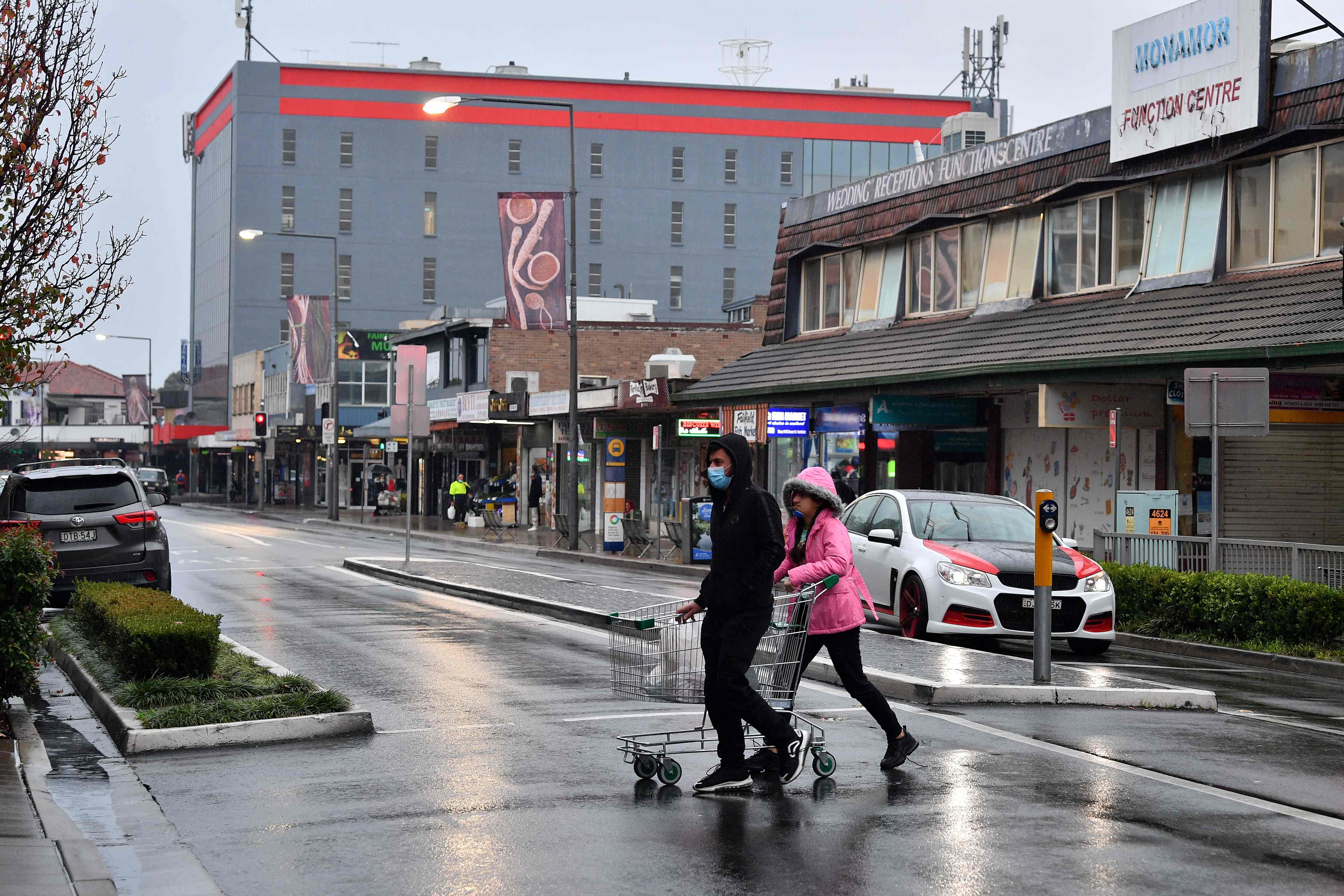 Warga mengenakan masker usai berbelanja di sebuah supermarket di Sydney, Australia.