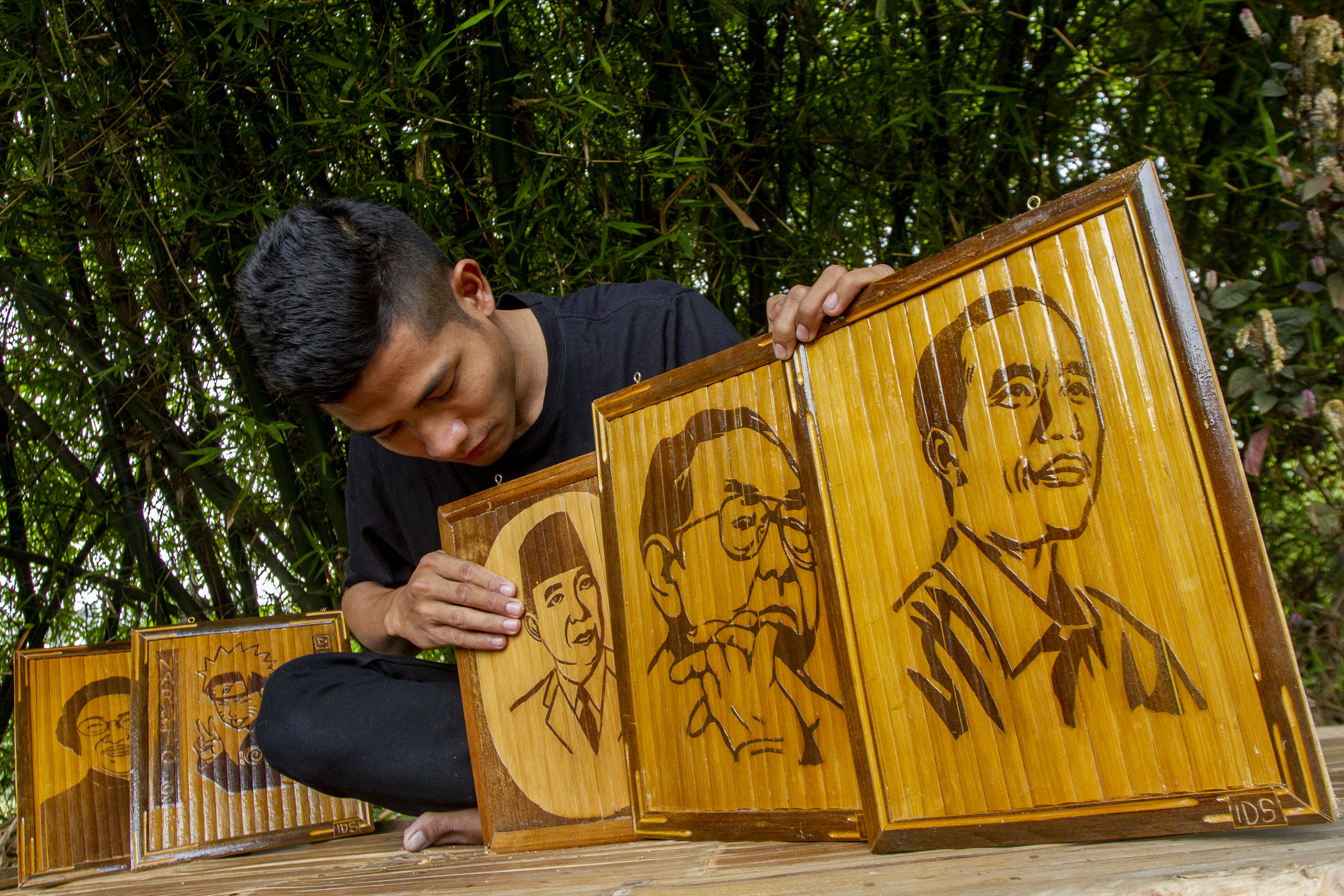 Perajin ukiran kayu berkarakter wajah merapiikan hasil karyanya