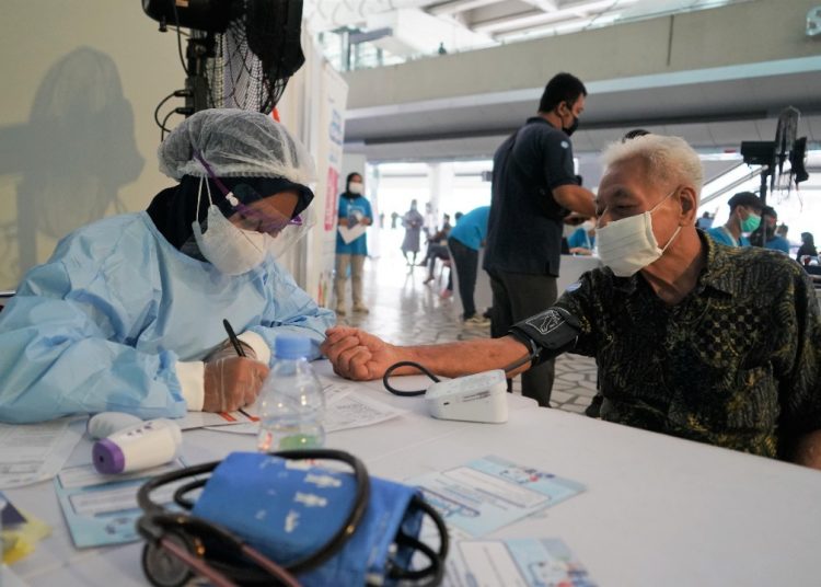 Petugas memeriksa warga yang akan divaksin covid-19 di Bandara Soekarno-Hatta.