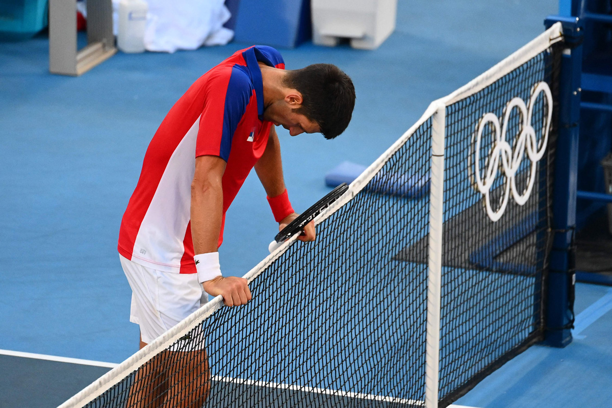 Petenis Serbia Novak Djokovic tertunduk lesu usai kalah di laga perebutan tempat ketiga cabang tenis Olimpiade Tokyo 2020, Sabtu (31/7).   