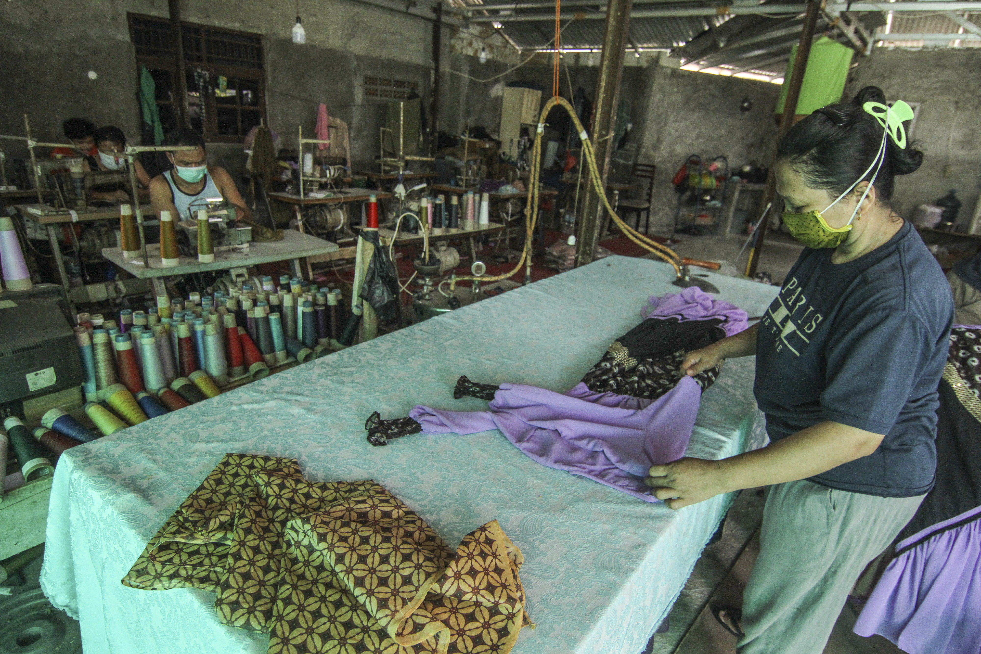 Pekerja tengah menyelesaikan pembuatan busana muslim di Konveksi Busana Muslim Yanto, Cipayung, Depok, Jawa Barat.