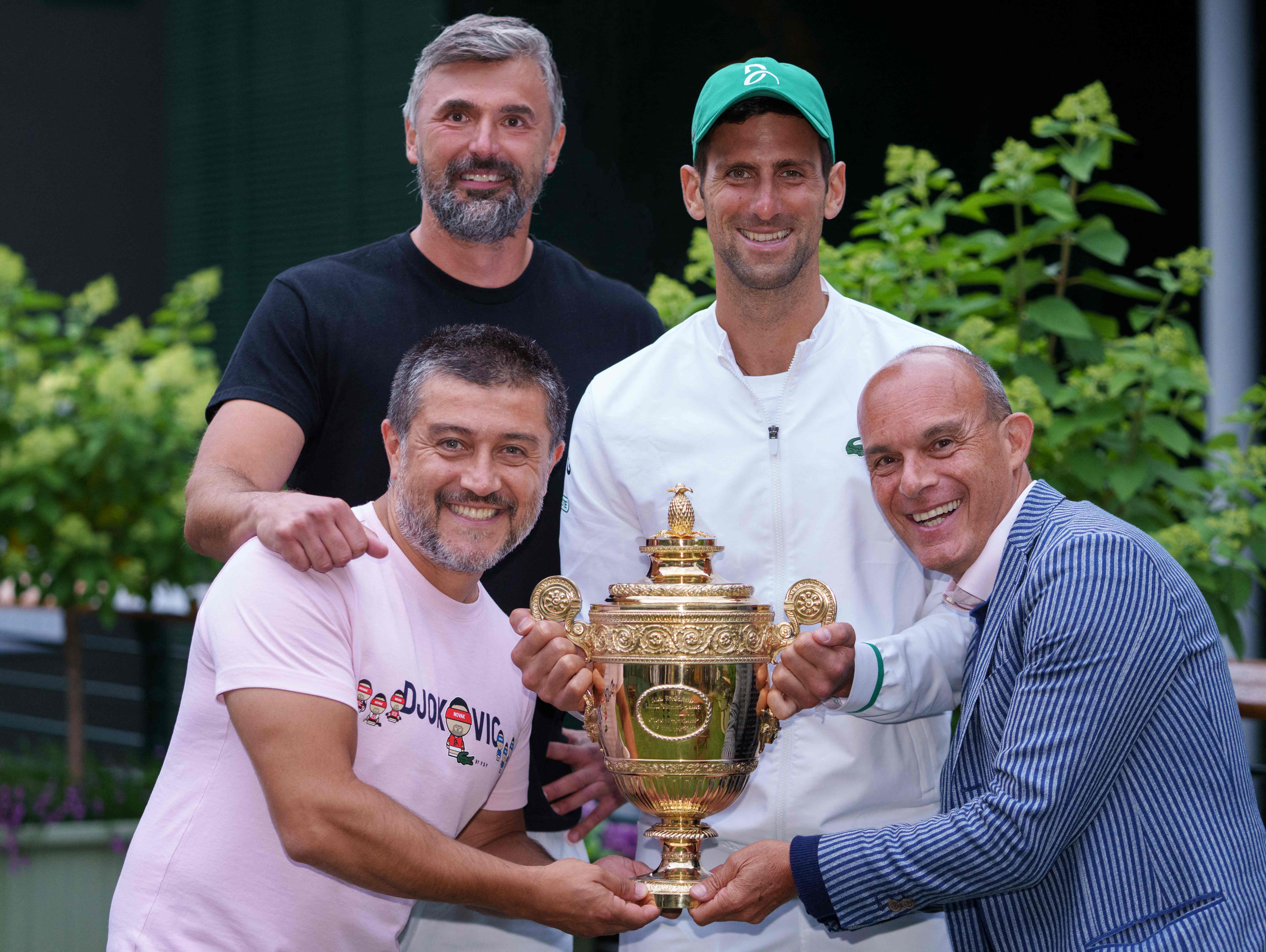 Petenis Serbia Novak Djokovic berpose dengan timnya usai menjadi juara Wimbledon.