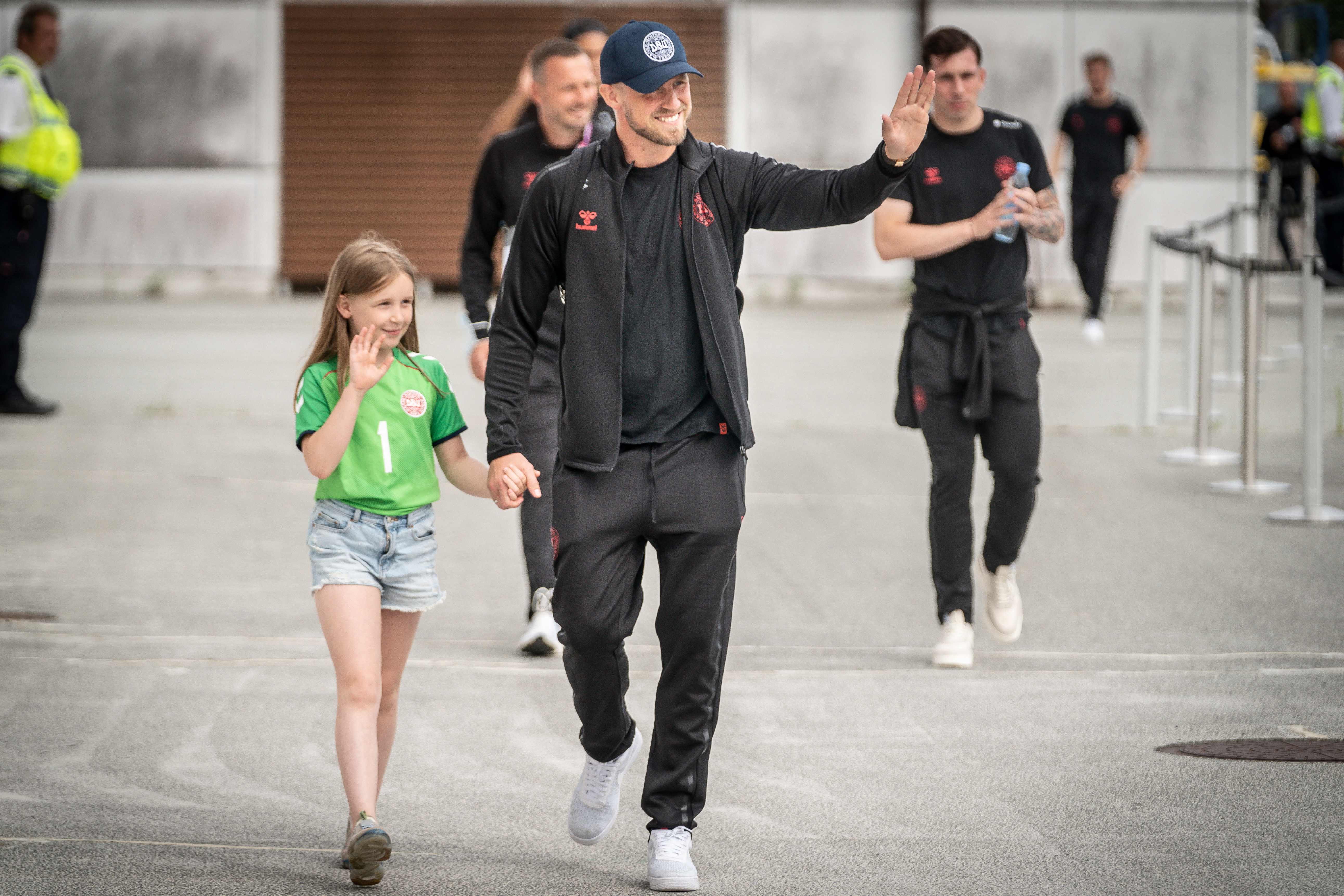 Penjaga gawang Kasper Schmeichel, bersama putrinya Isabella, melambai kepada para penggemar setelah tim mendarat di Bandara Kopenhagen, Kam 