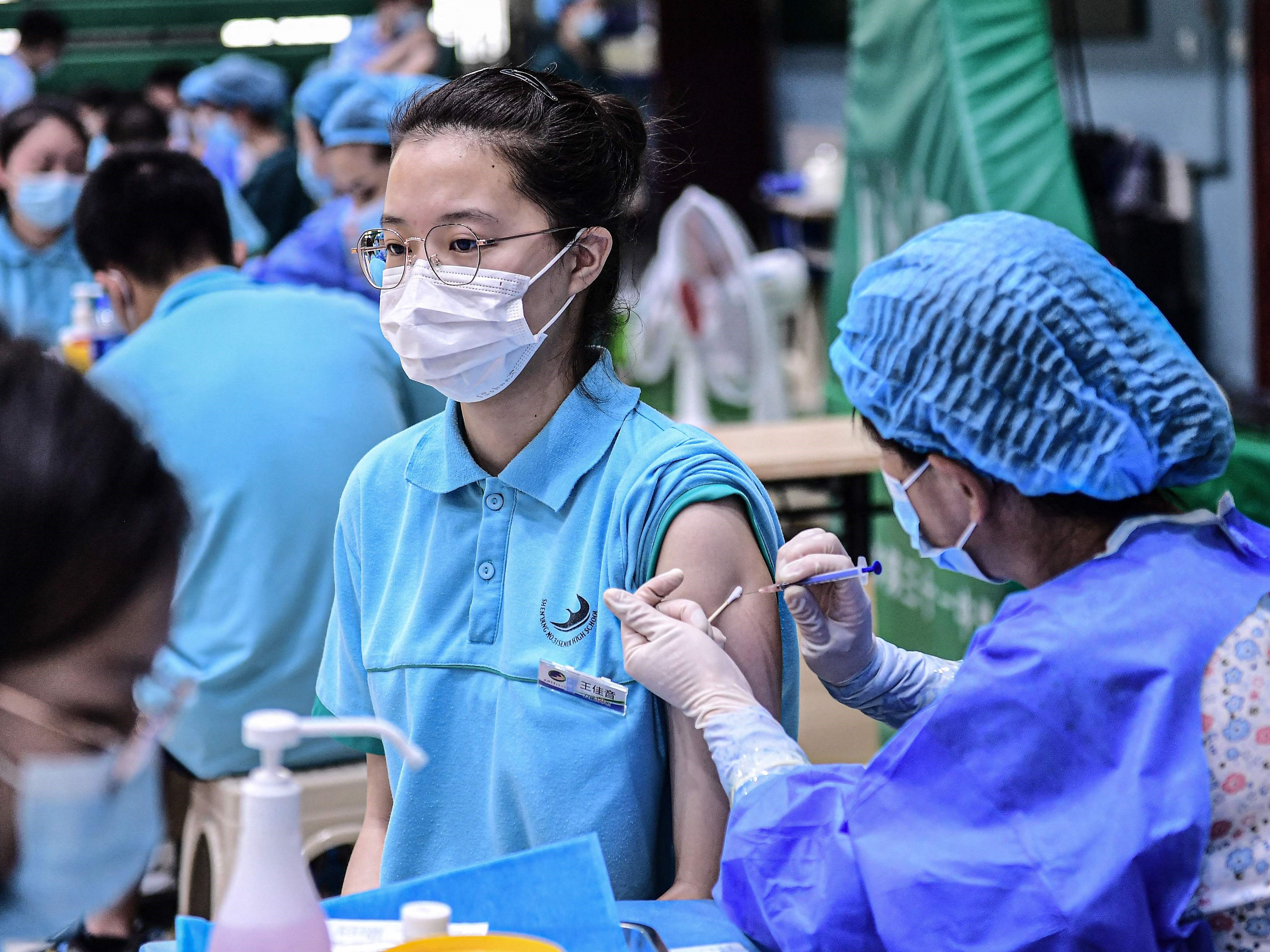 Seorang siswa (kiri) menerima vaksin covid-19 Sinopharm di sekolah menengah, Shenyang, Provinsi Liaoning, Tiongkok, Rabu (28/7).