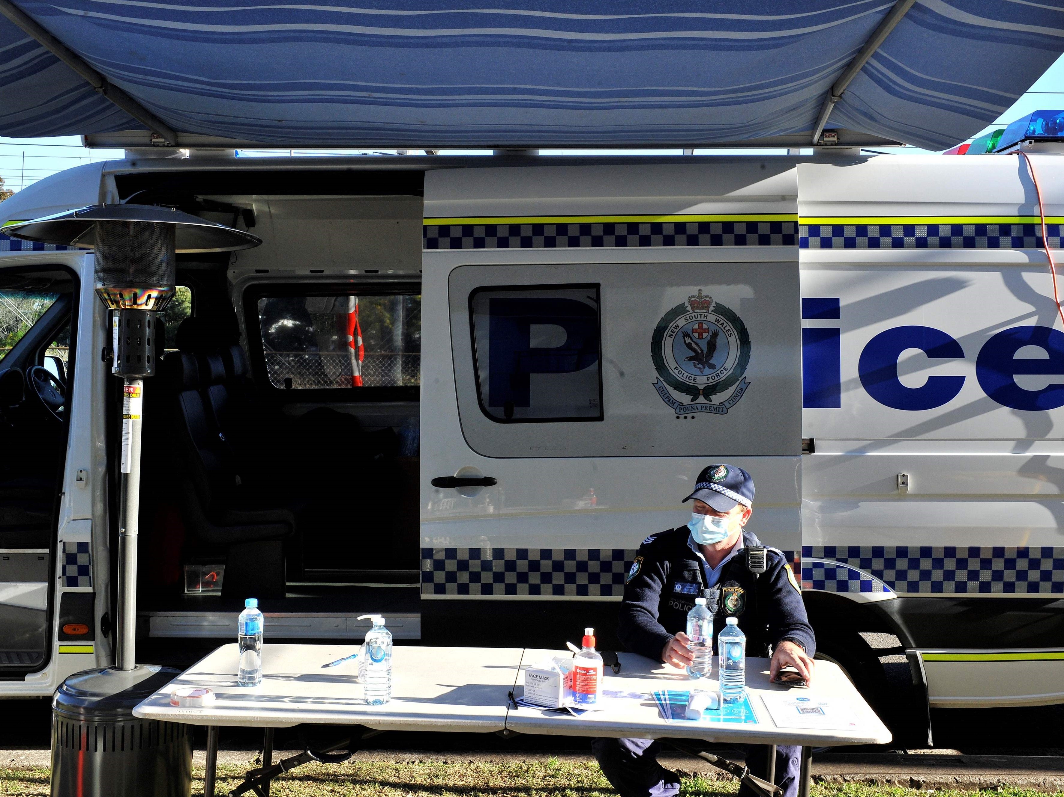 Mobil polisi berada di luar bangunan tempat tinggal yang diisolasi akibat covid-19, Blacktown, pinggiran barat Sydney, Kamis (29/7).