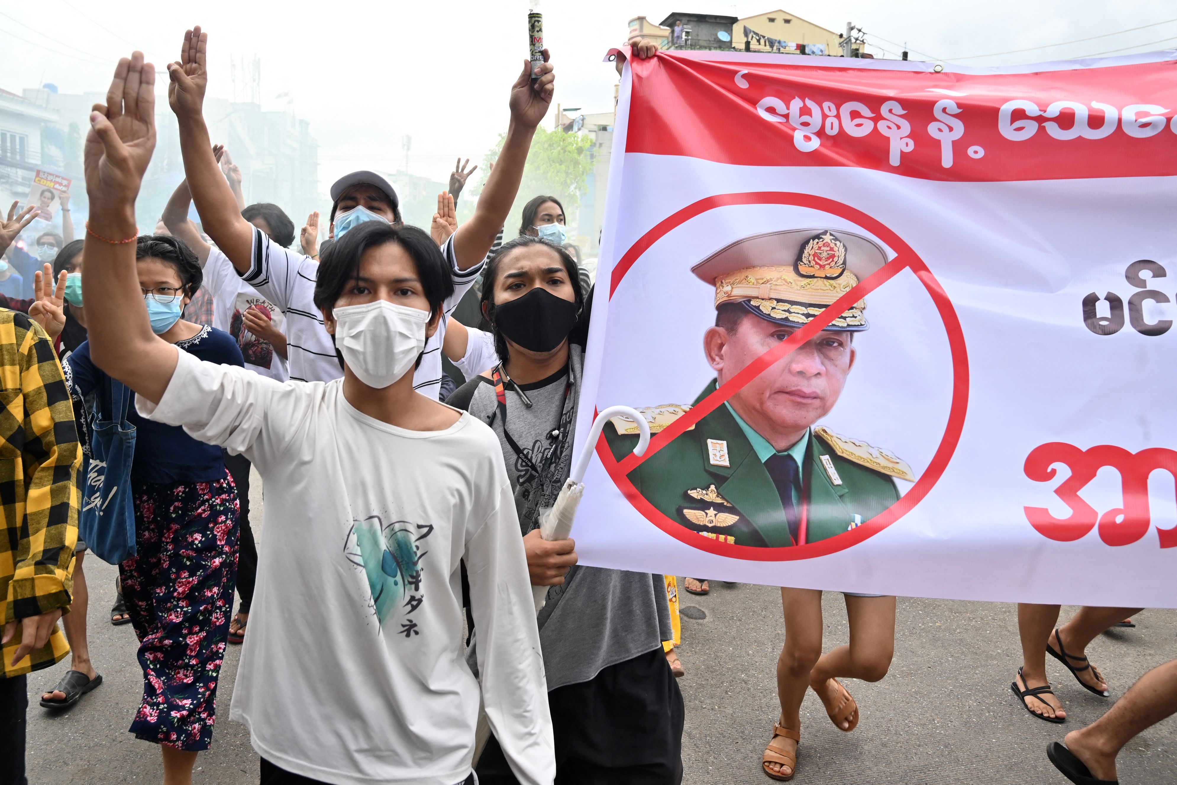 Para pengunjuk rasa membawa poster dengan gambar pemimpin junta militer Jenderal Senior Min Aung Hlaing di Yangon, Myanmar, Sabtu (3/7).
