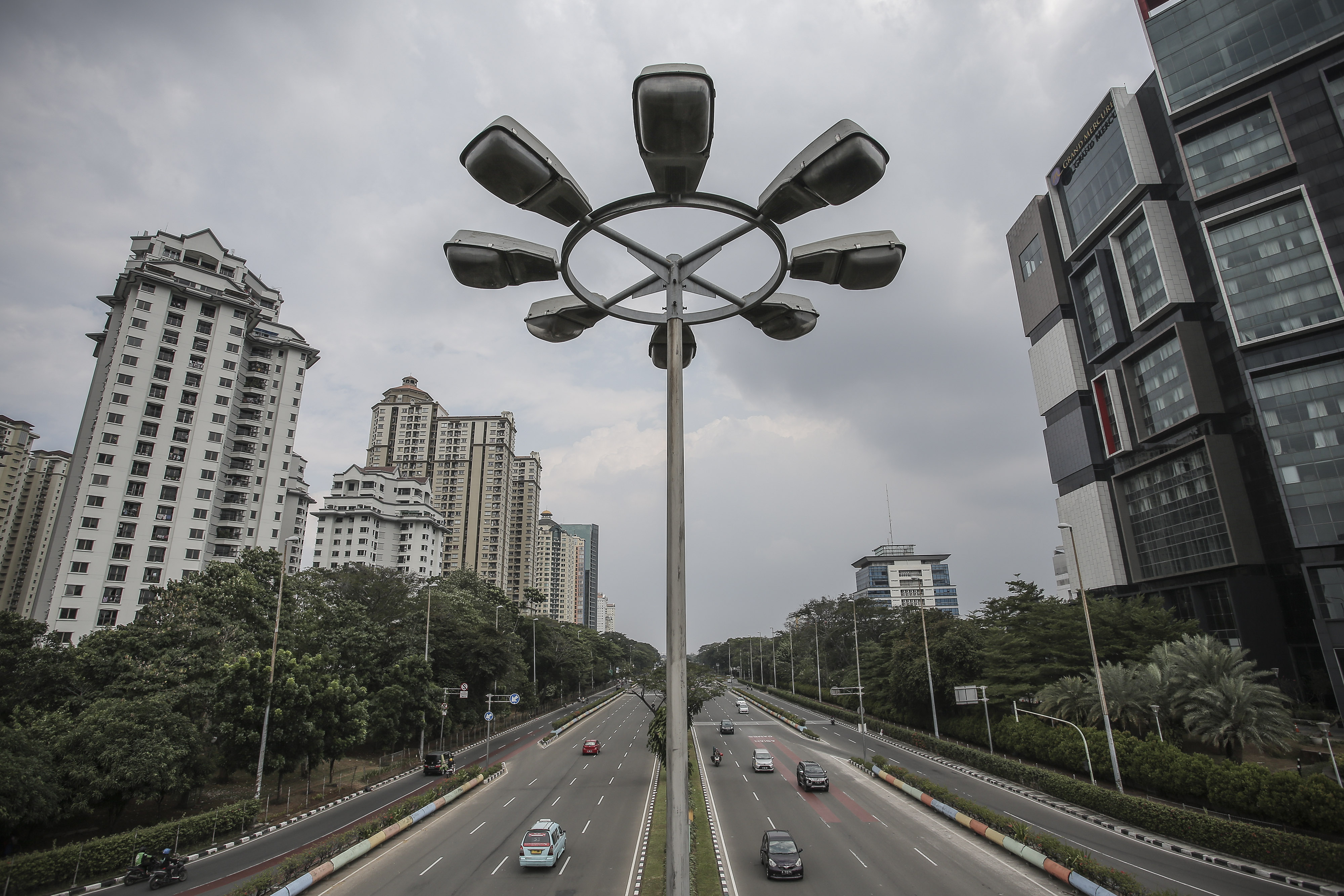 Kendaraan melintas dengan latar gedung bertingkat di kawasan Kemayoran, Jakarta.