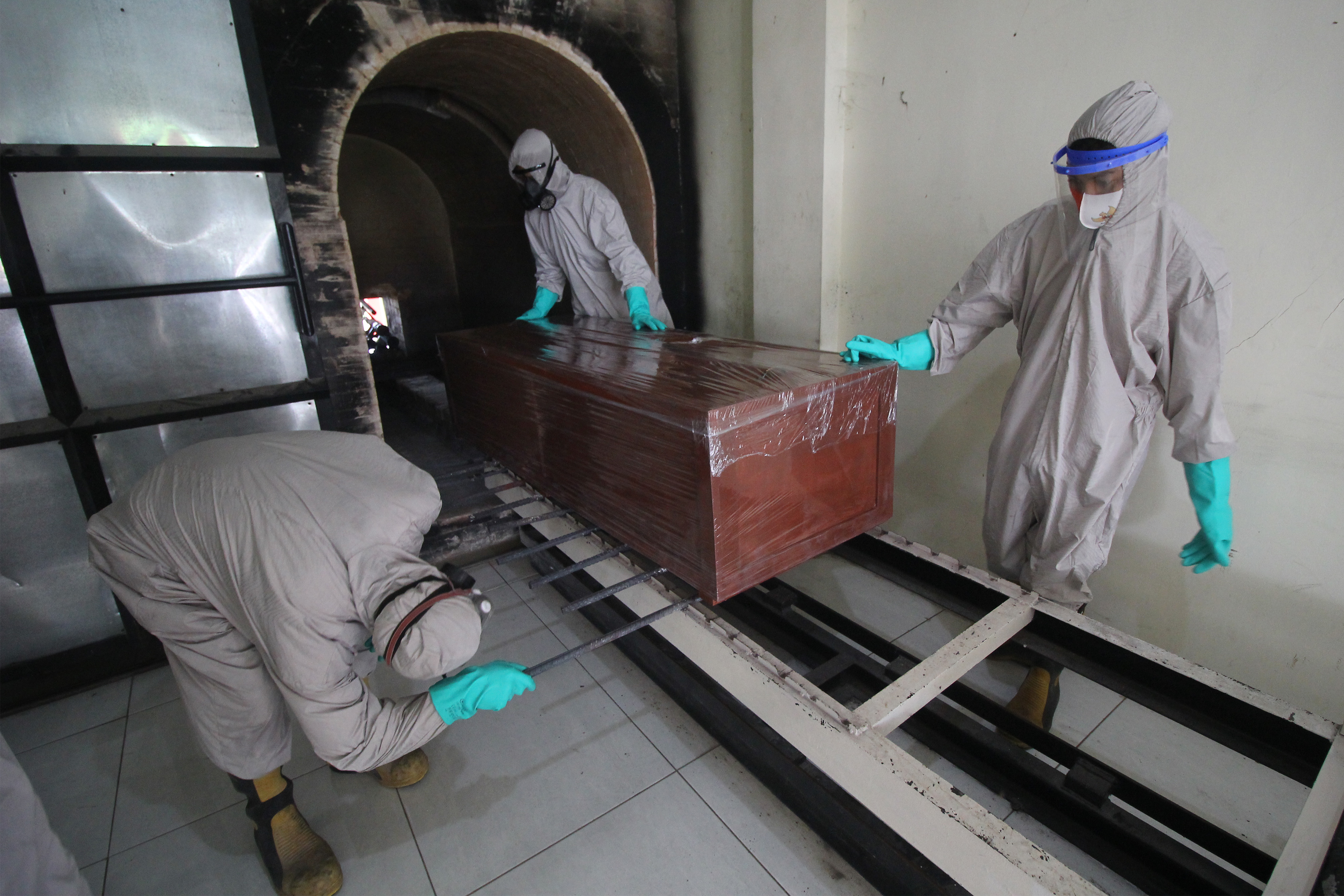 Ilustrasi--Petugas memasukkan peti jenazah pasien covid-19 untuk dikremasi di Krematorium Keputih, Surabaya, Jawa Timur.