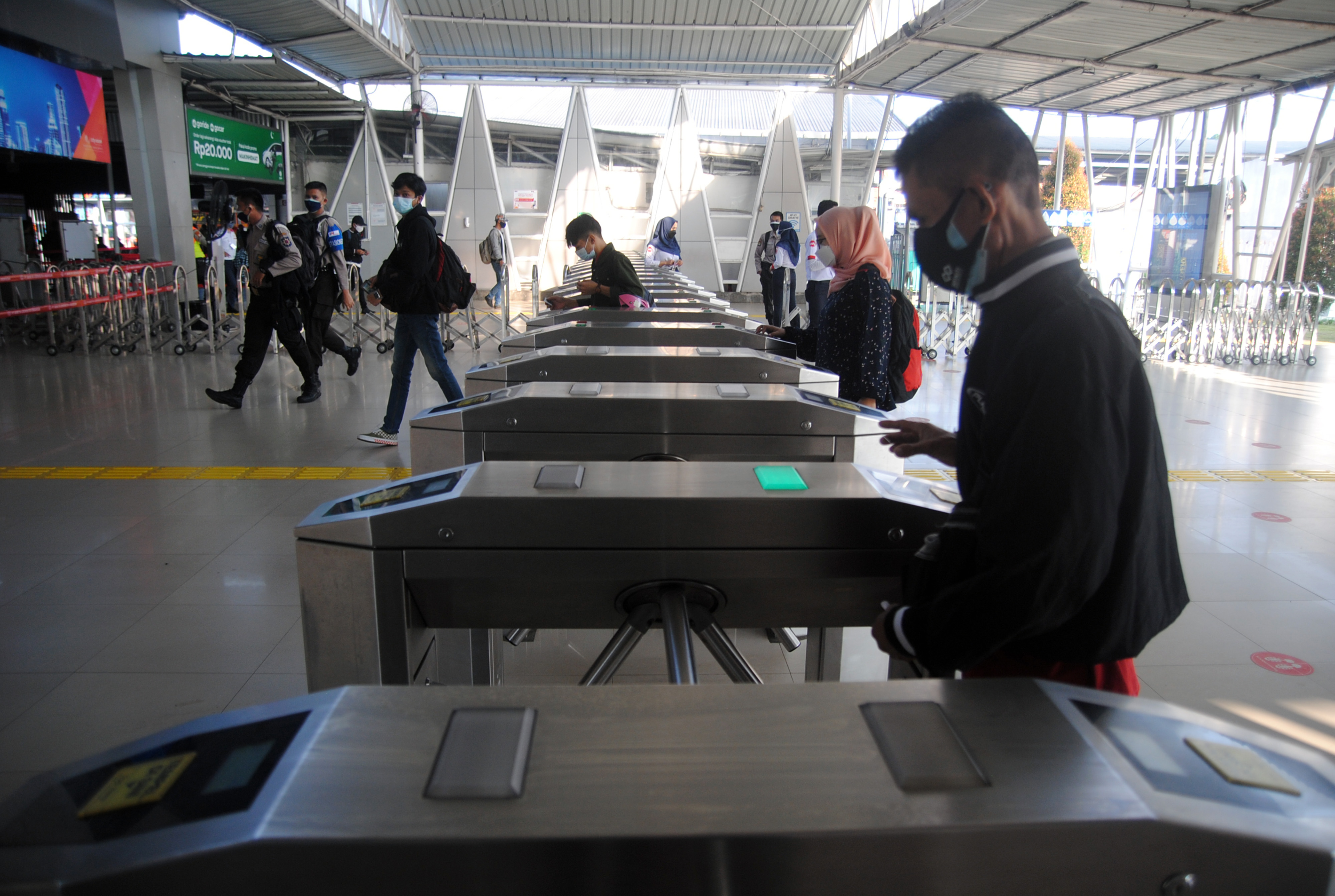 Penumpang KRL menggunakan 2 masker