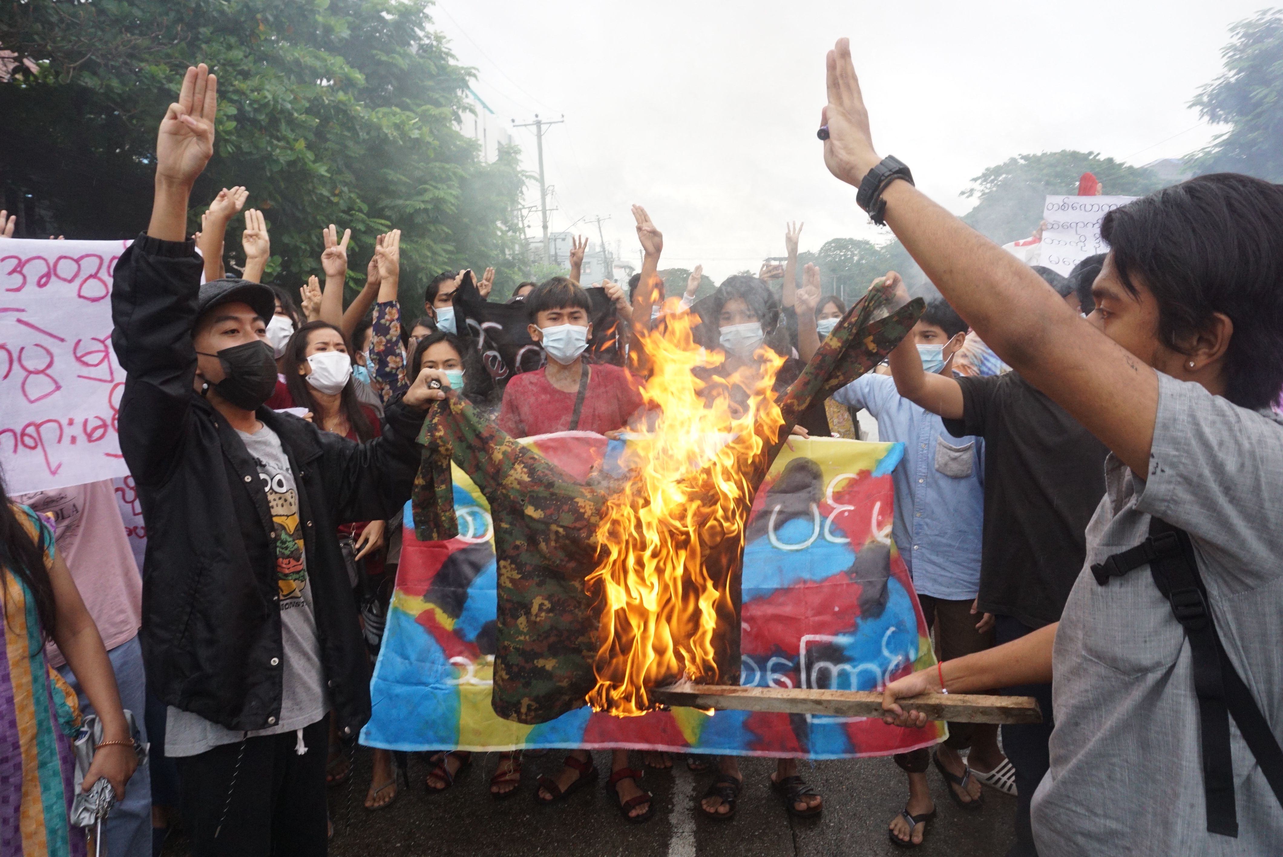 Demonstran membakar seragam militer di Yangon, Myanmar.
