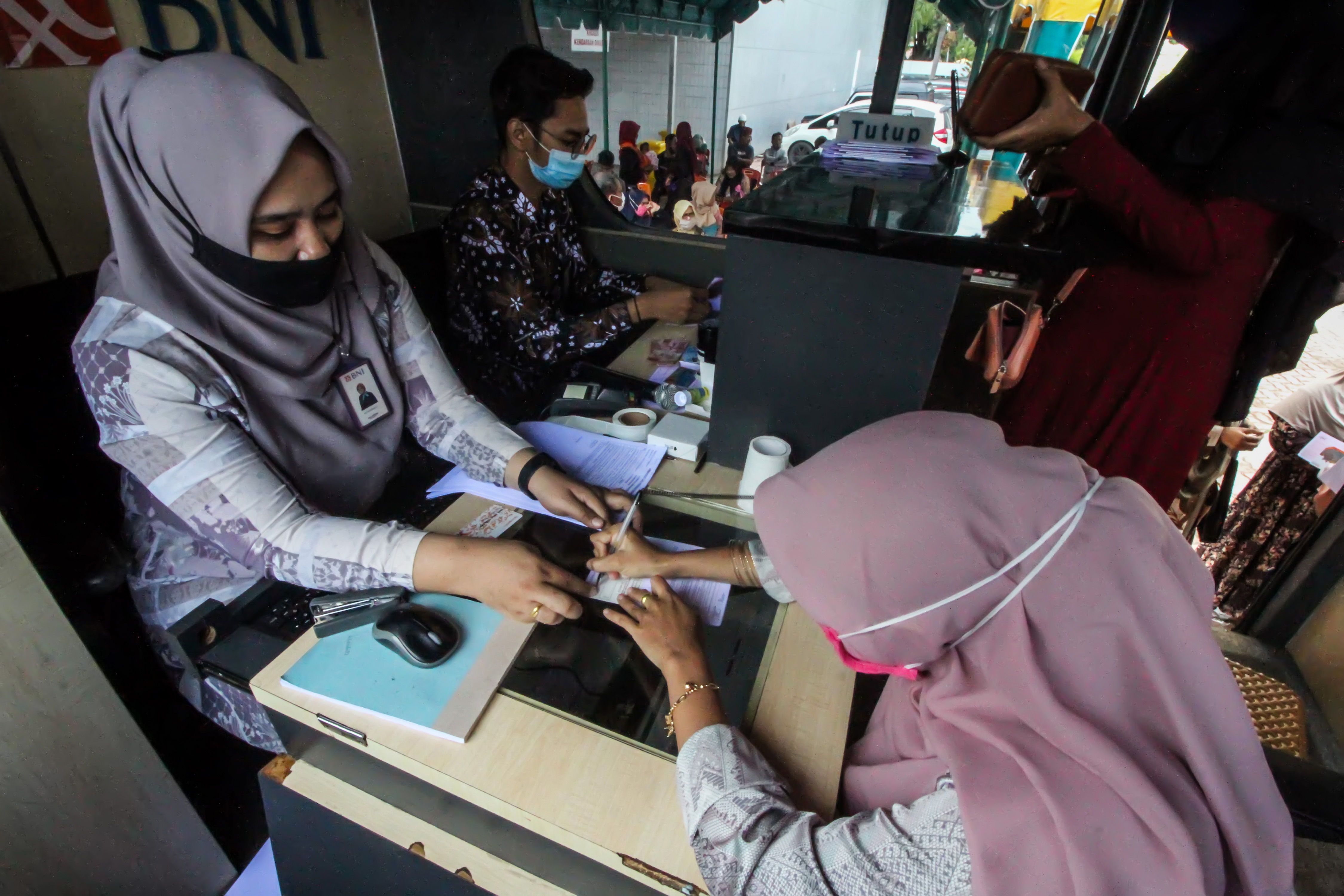 Guru honorer meneken dokumen buku tabungan saat pencairan bantuan subsidi upah di Lhokseumawe, Aceh.