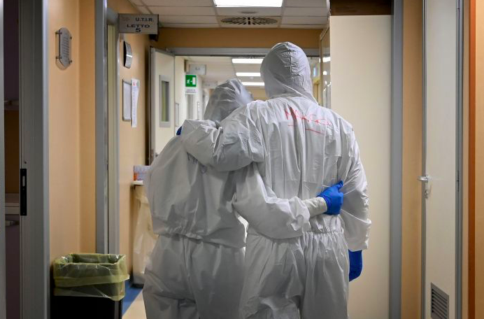 Ilustrasi - Dokter dan perawat pasien Covid-19 menggunakan alat pelindung diri di koridor rumah sakit, Italia.