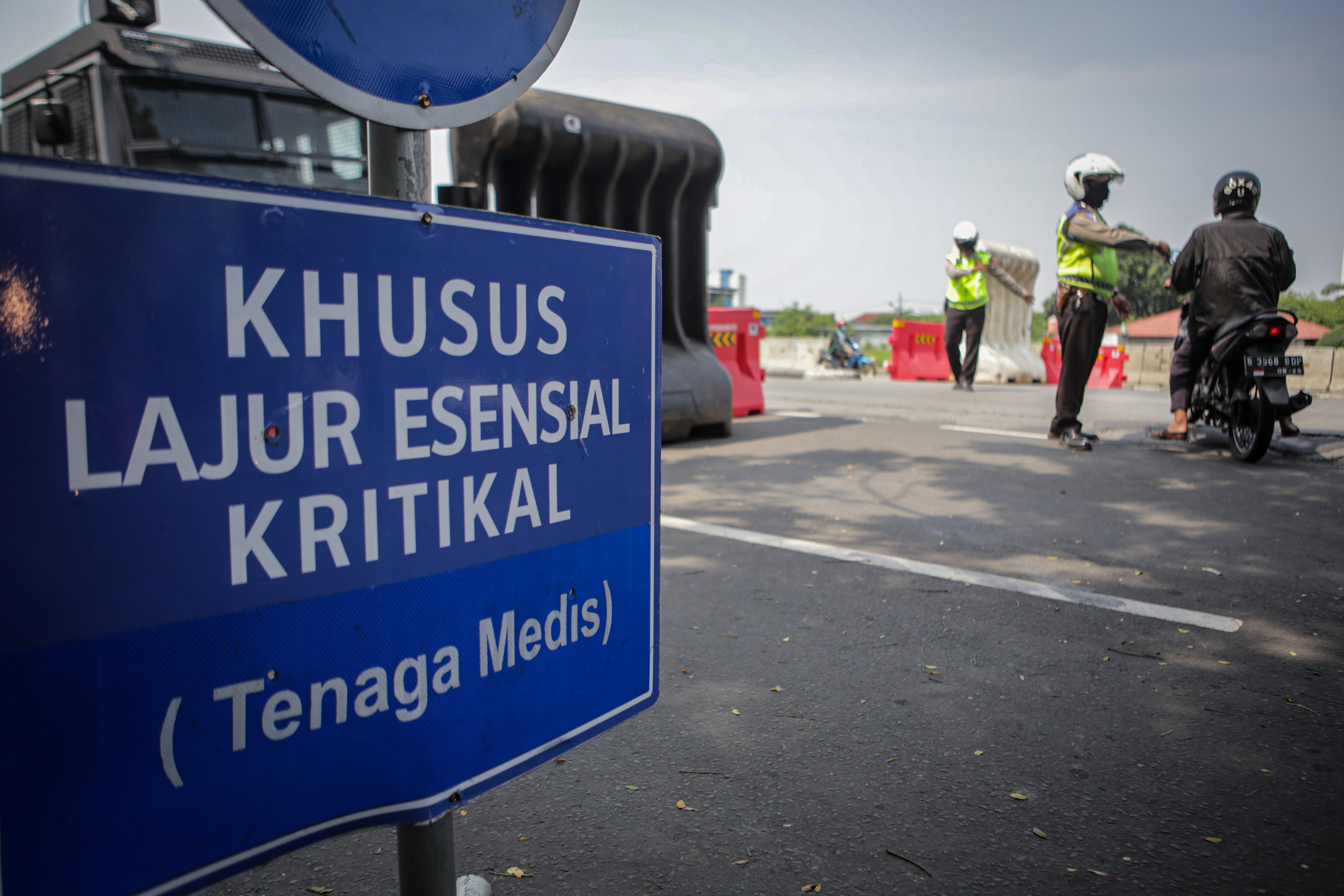 Polisi memeriksa dokumen perjalanan pengemudi yang akan melintasi pos penyekatan.