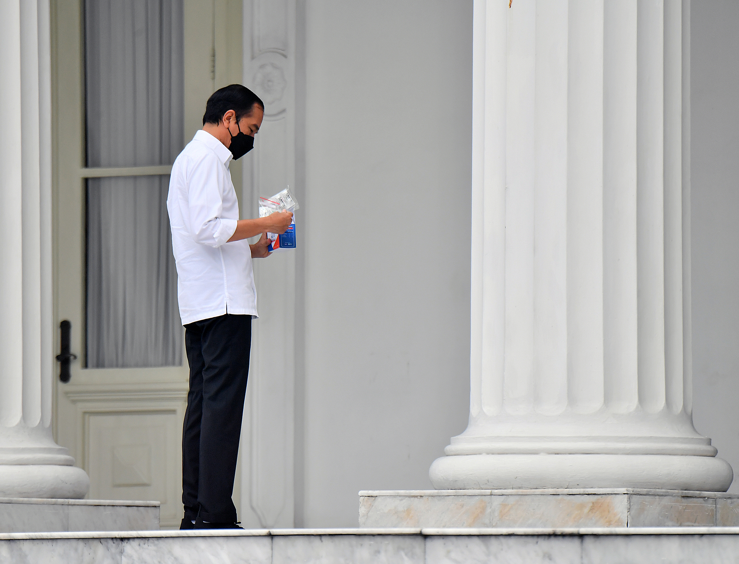 Presiden Joko Widodo memeriksa paket obat dan vitamin yang akan diberikan pada masyarakat penderita Covid-19
