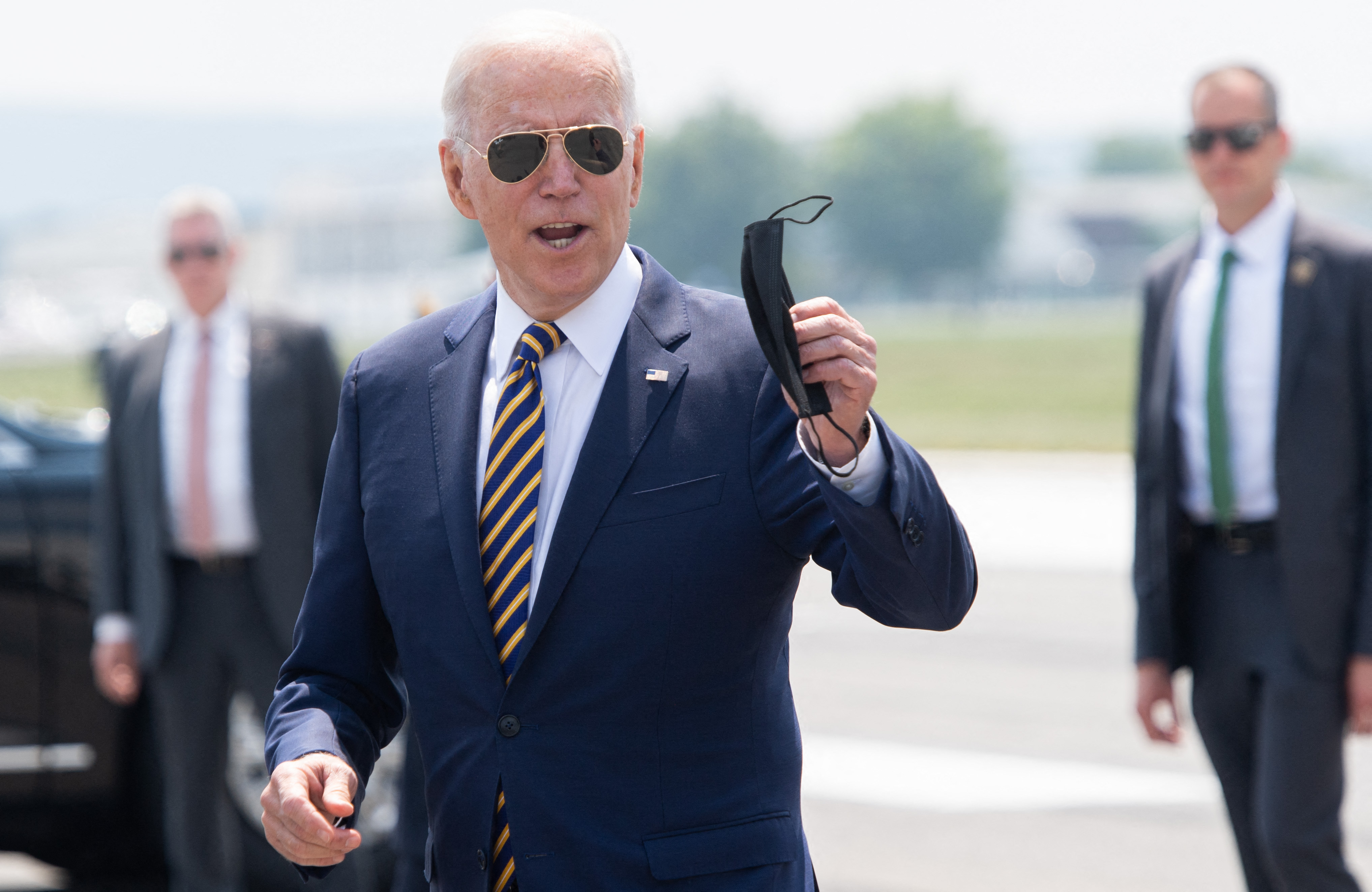 Presiden Joe Biden membuka maskernya saat menjawab pertanyan wartawan.
