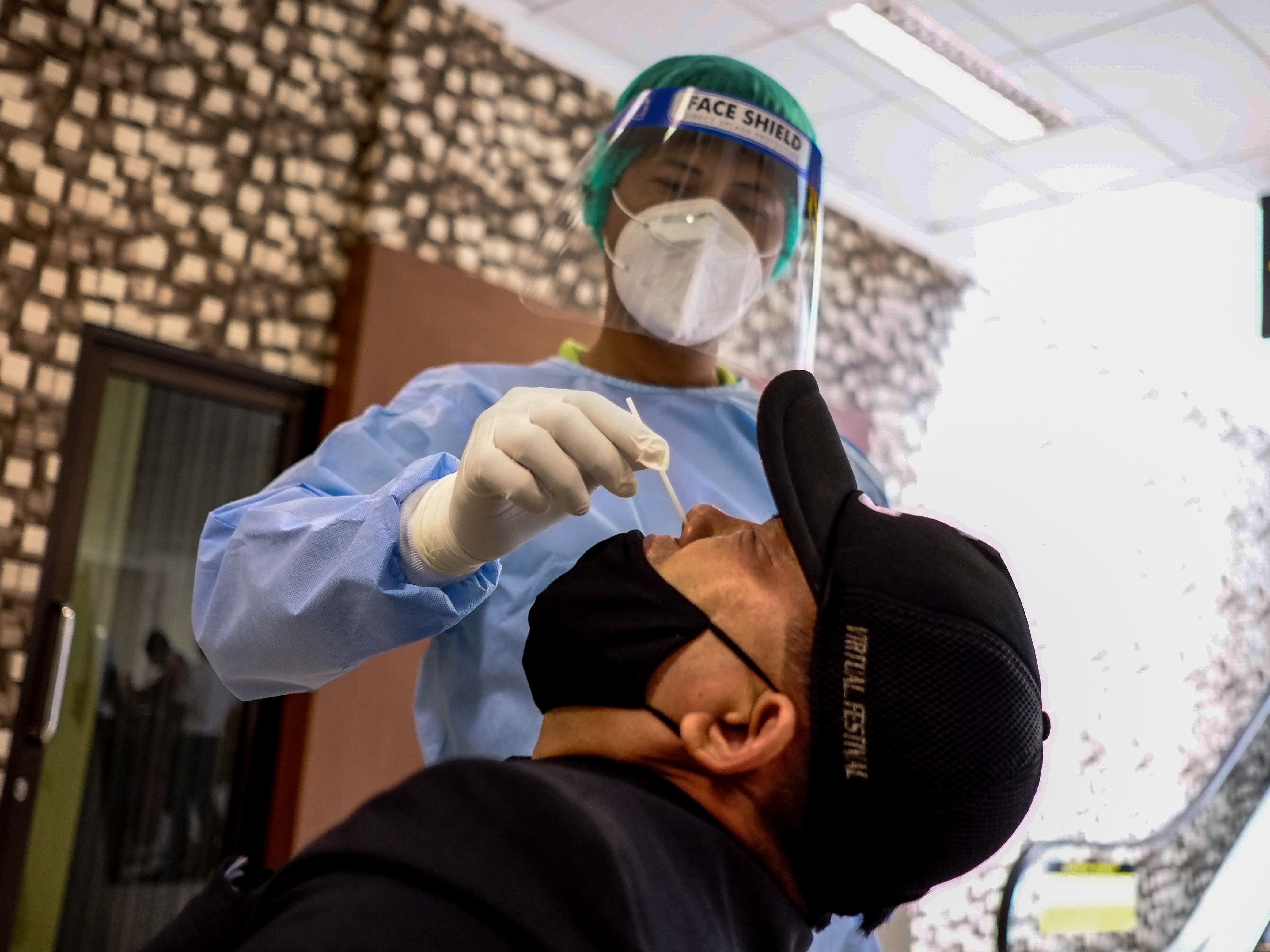 Petugas kesehatan melakukan tes cepat antigen kepada seorang pemudik yang baru tiba di Terminal Kedatangan Bandara Depati Amir.