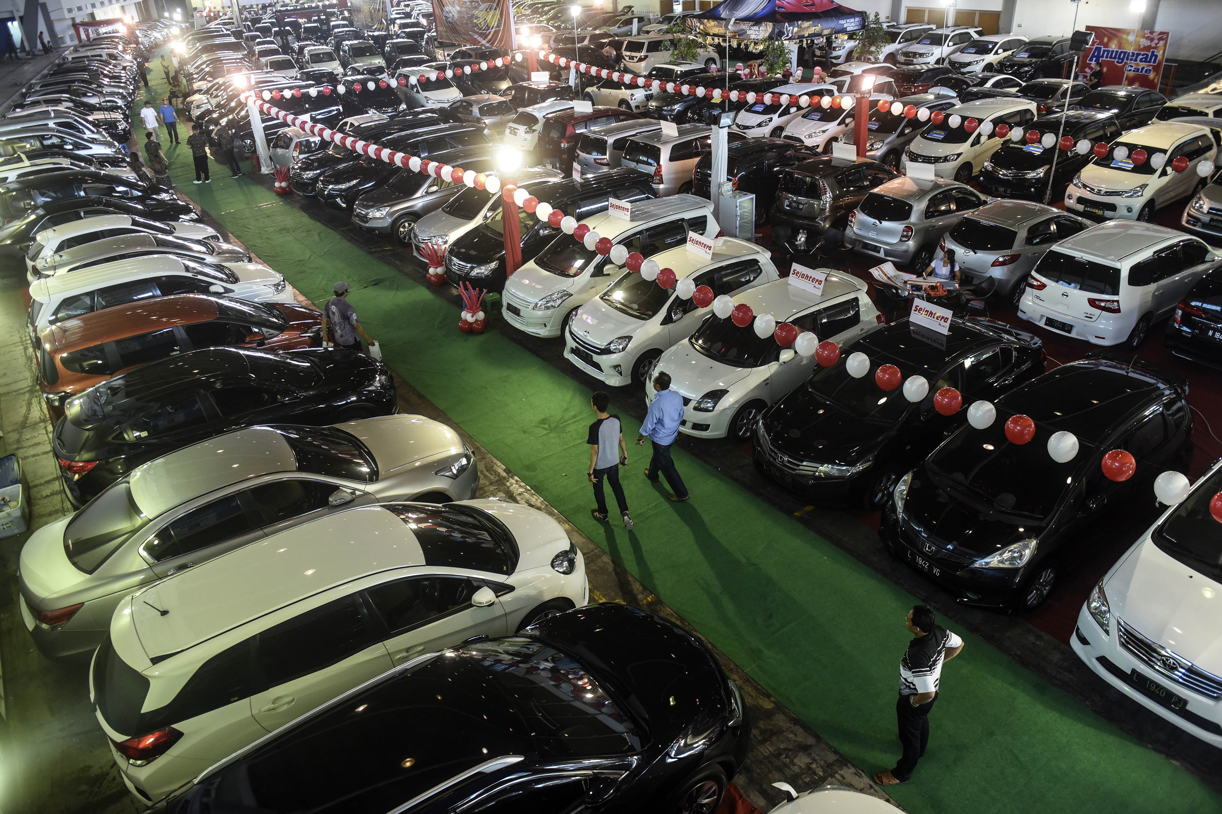 Pengunjung mengamati mobil bekas yang dijual pada ajang Bazaar Mobil Bekas di JX International Convention Hall, Surabaya, Jawa Timur.