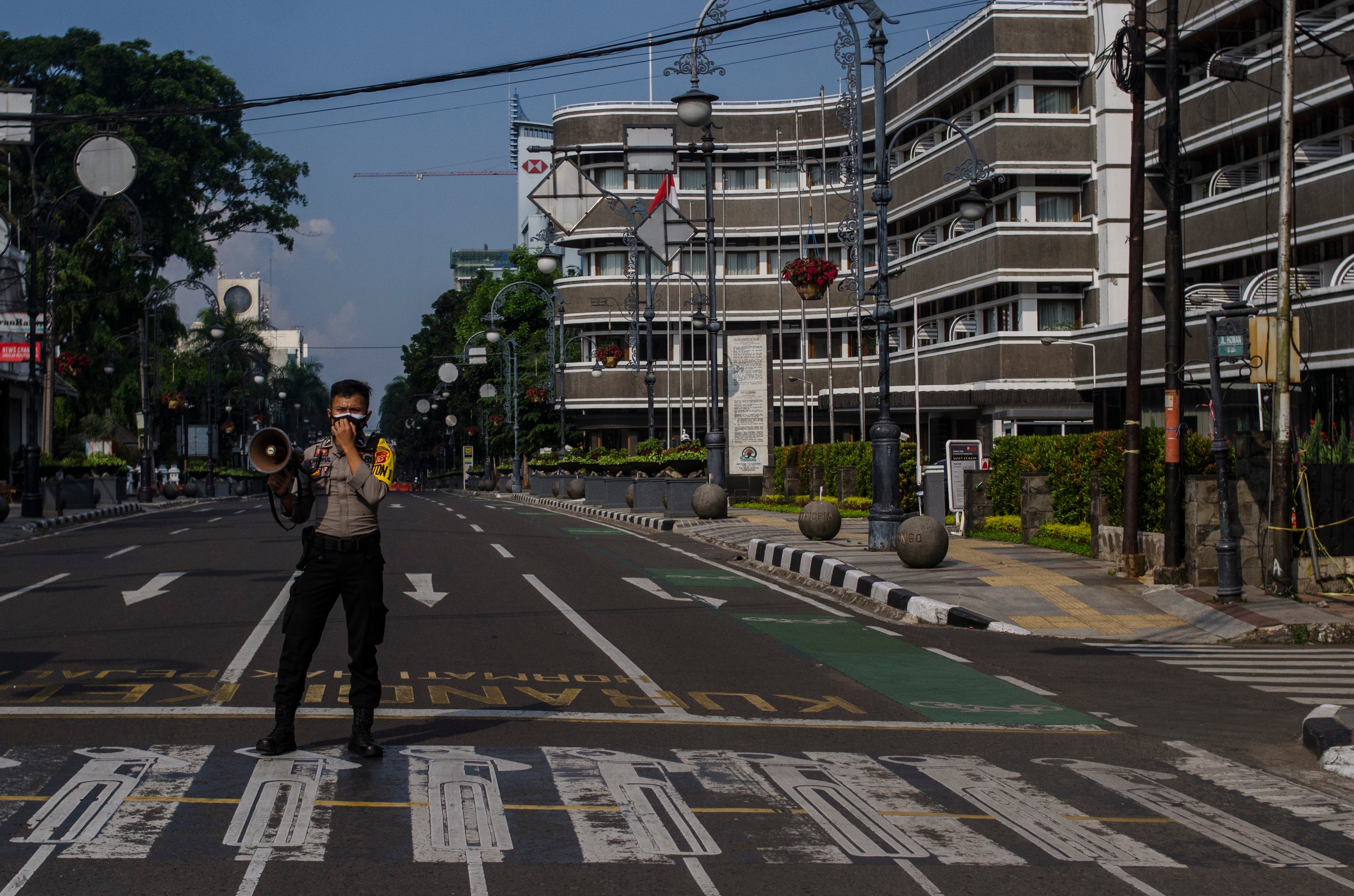   Petugas melakukan penutupan Jalan Asia Afrika, Kota Bandung, Jawa Barat, dalam rangka pelaksanaan PPKM Darurat
