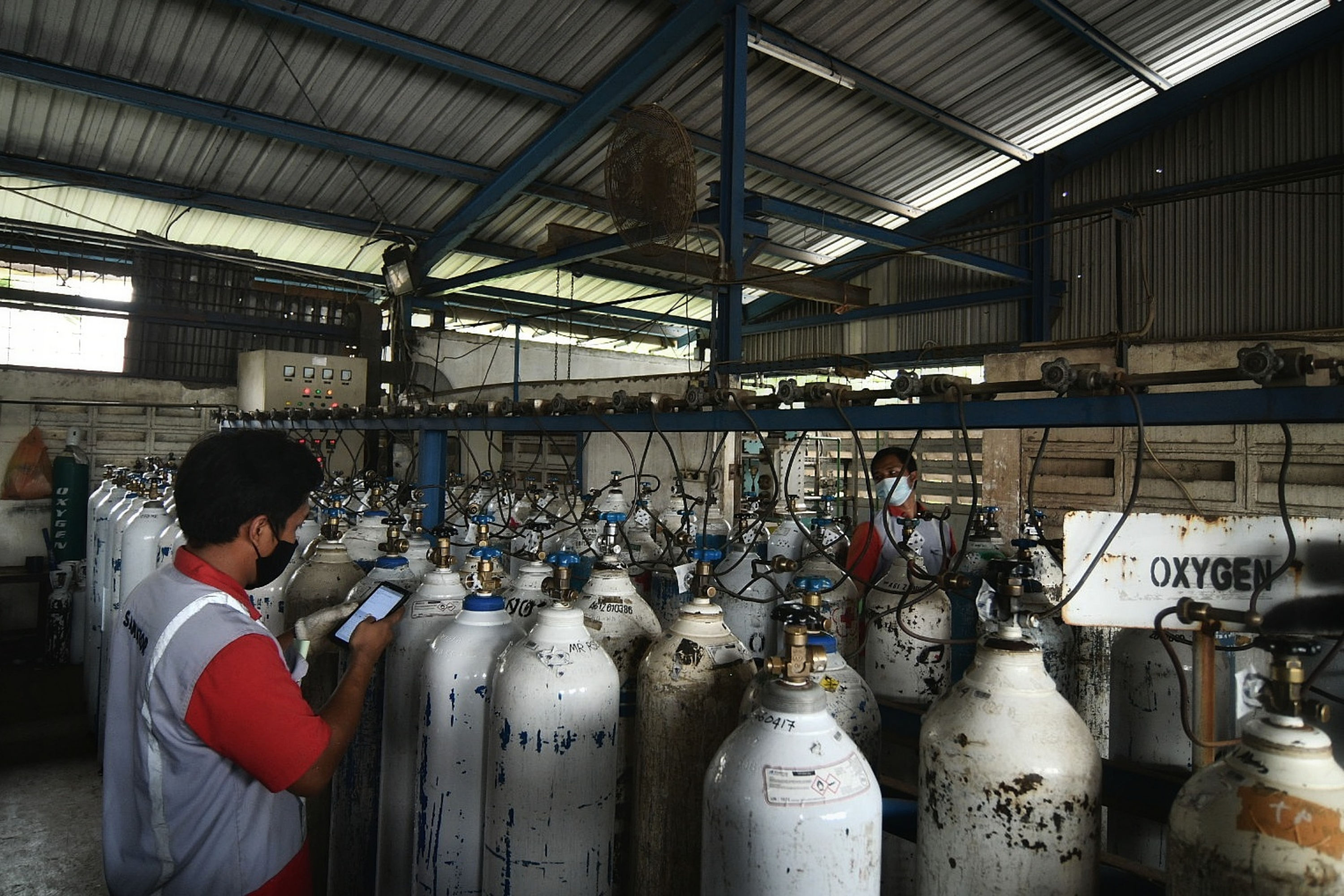Pekerja melakukan pengisian ulang tabung oksigen di tempat pengisian oksigen PT Aneka Gas Industri, Jakarta Timur.