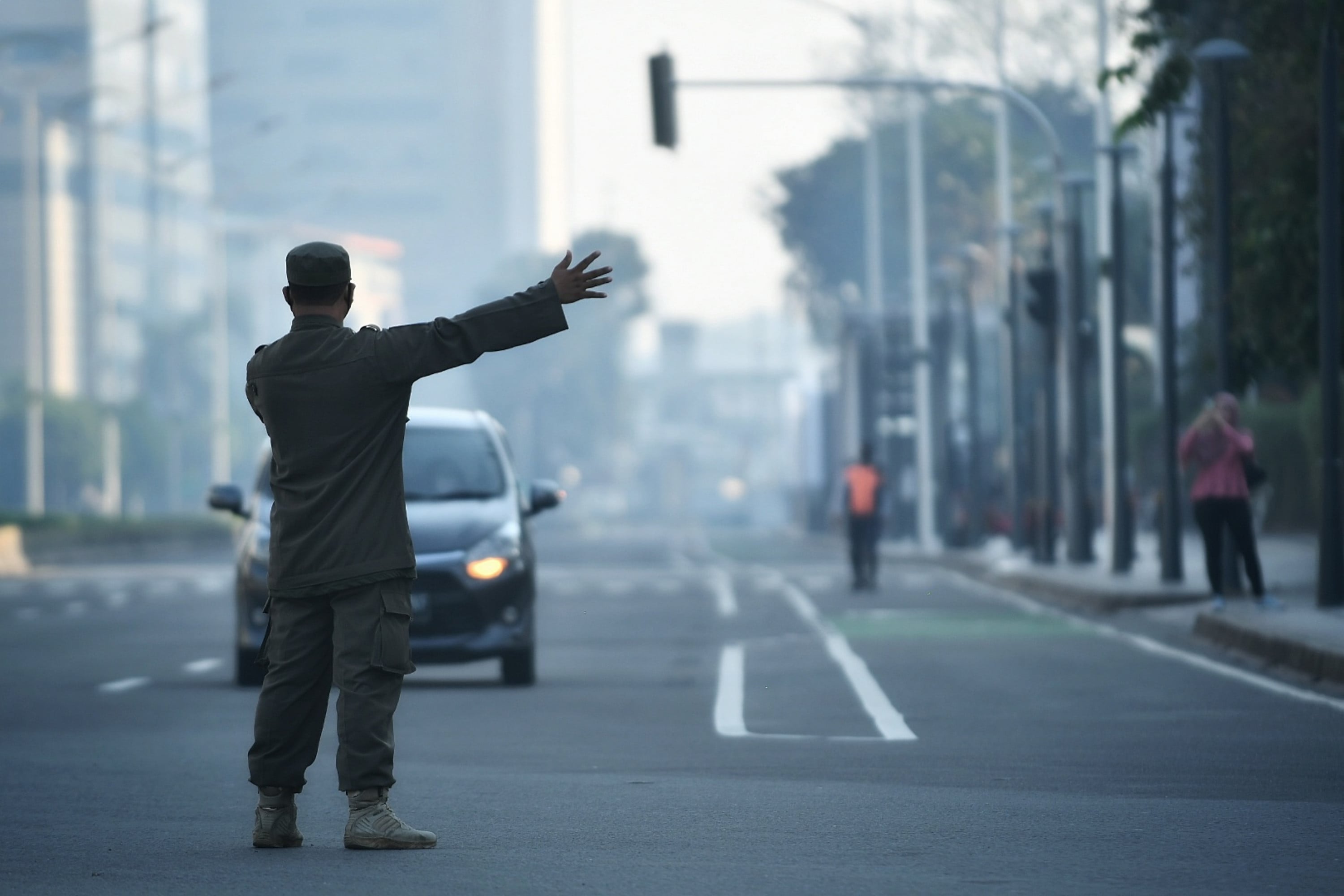 Petugas Satpol PP saat mengarahkan kendaraan agar keluar dari kawasan Sudirman-Thamrin, Jakarta.