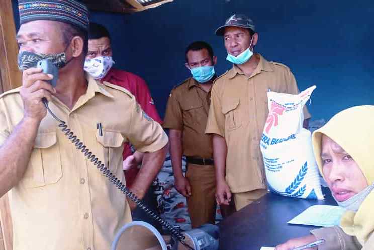 Warga penerima bantuan beras PPKM dipanggil saat pembagian dilakukan oleh Pemerintah Desa Golo Bilas.