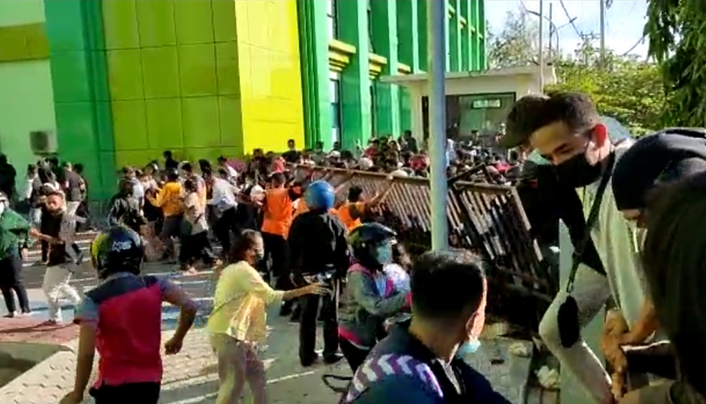 Ribuan orang yang mengante untuk divaksinasi Covid-19 merobohkan gerbang Gedung Jurusan Farmasi, Poltekes Kemenkes Kupang, NTT, Rabu (14/7)