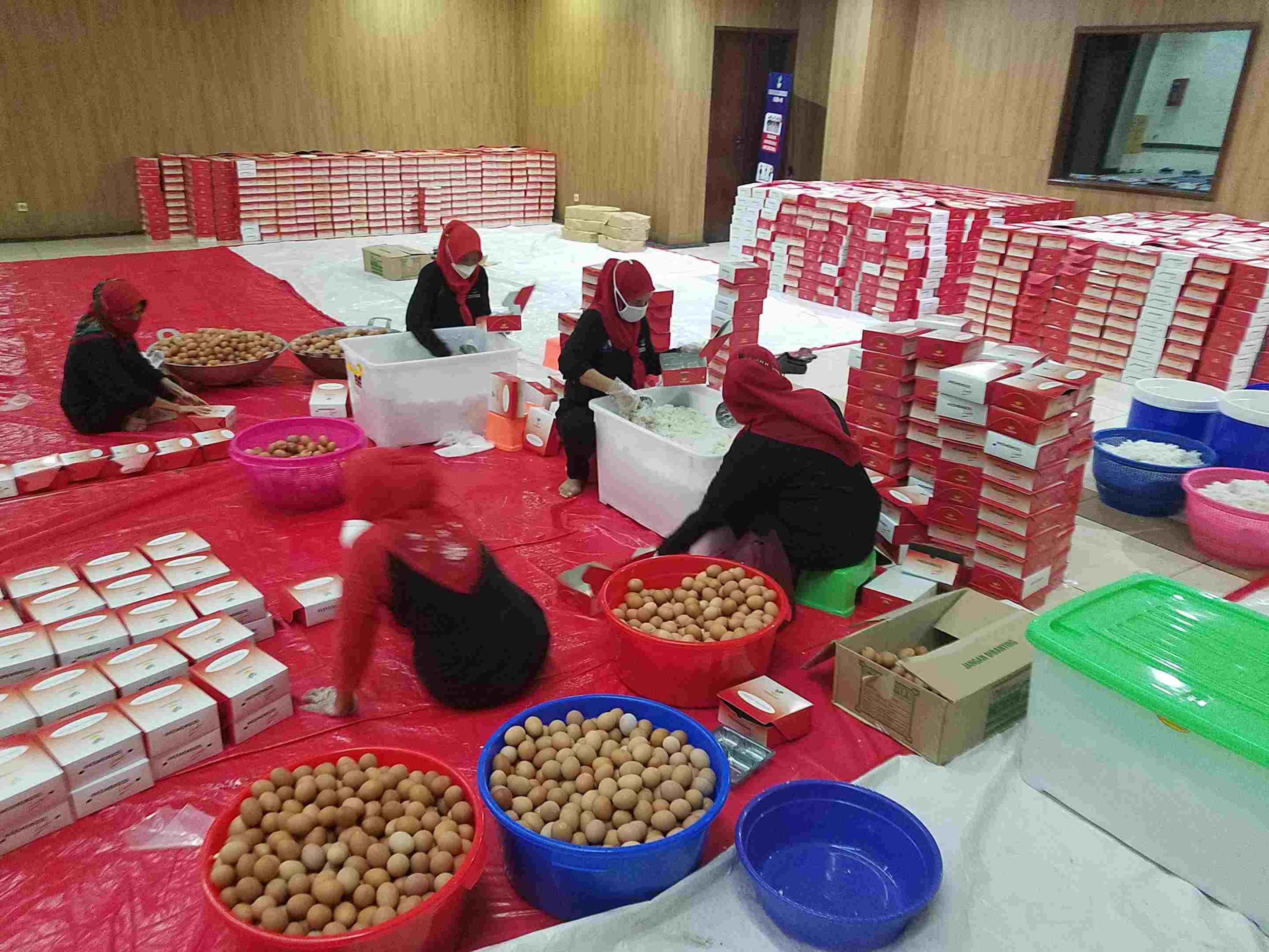 Petugas dapur umum balai Kemensos di Kota Bekasi tengah menyiapkan makanan bagi 13 ribuan nakes dan warga yang isoman di wilayahnya.