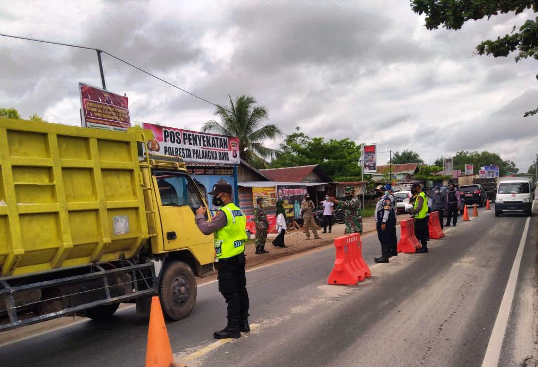 Petugas Kepolisian berjaga di Pos Penyekatan Polresta Palangka Raya di Jalan Mahir Mahar, Kota Palangka Raya, Kalimantan Tengah