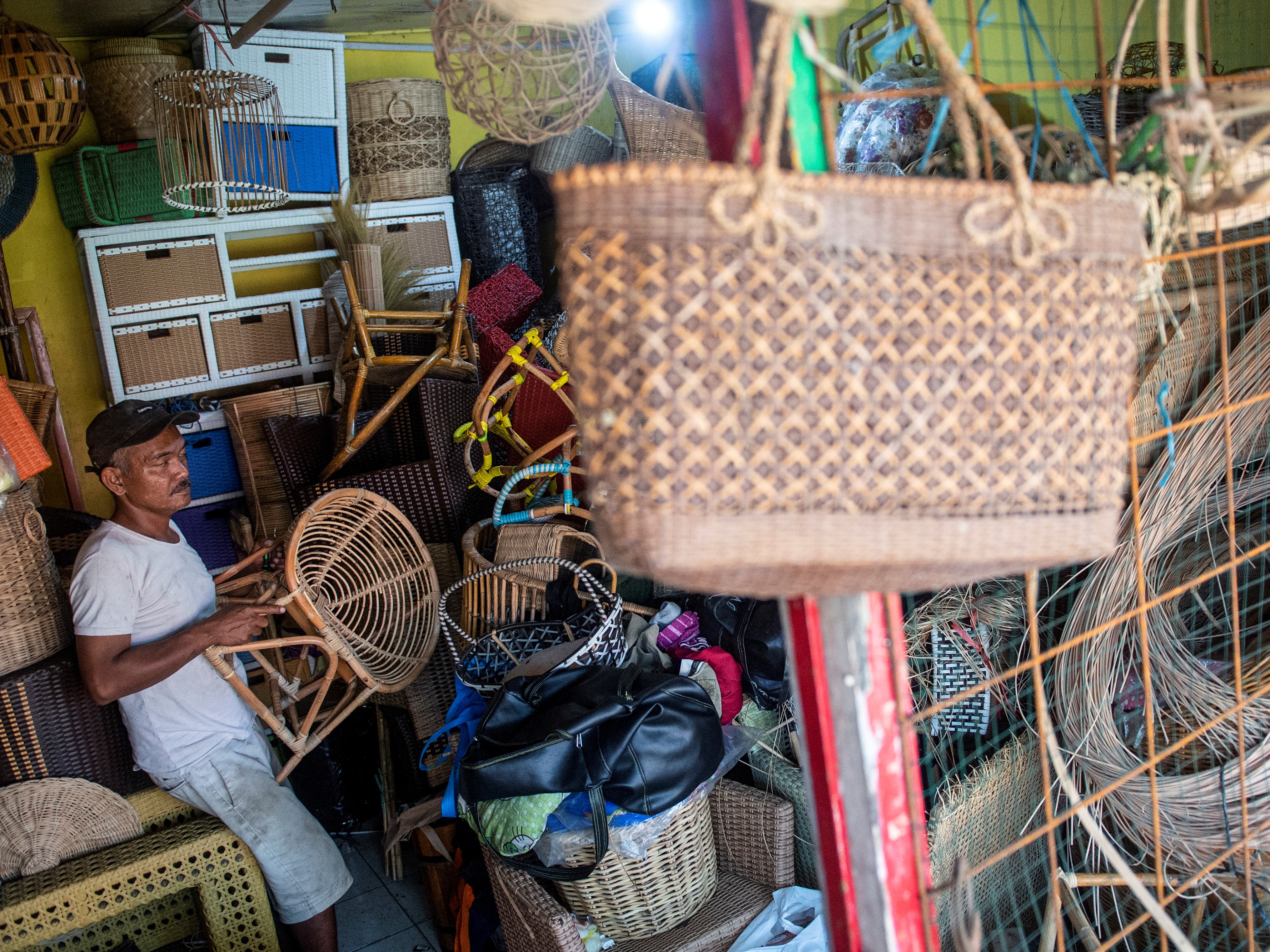 Perajin memindahkan kerajinan kursi rotan di salah satu UMKM di kawasan Pasar Minggu, Jakarta, Senin (26/7).