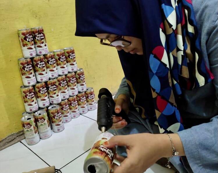 Ilustrasi, seorang pengajar tengah berkreasi dengan kaleng bekas.