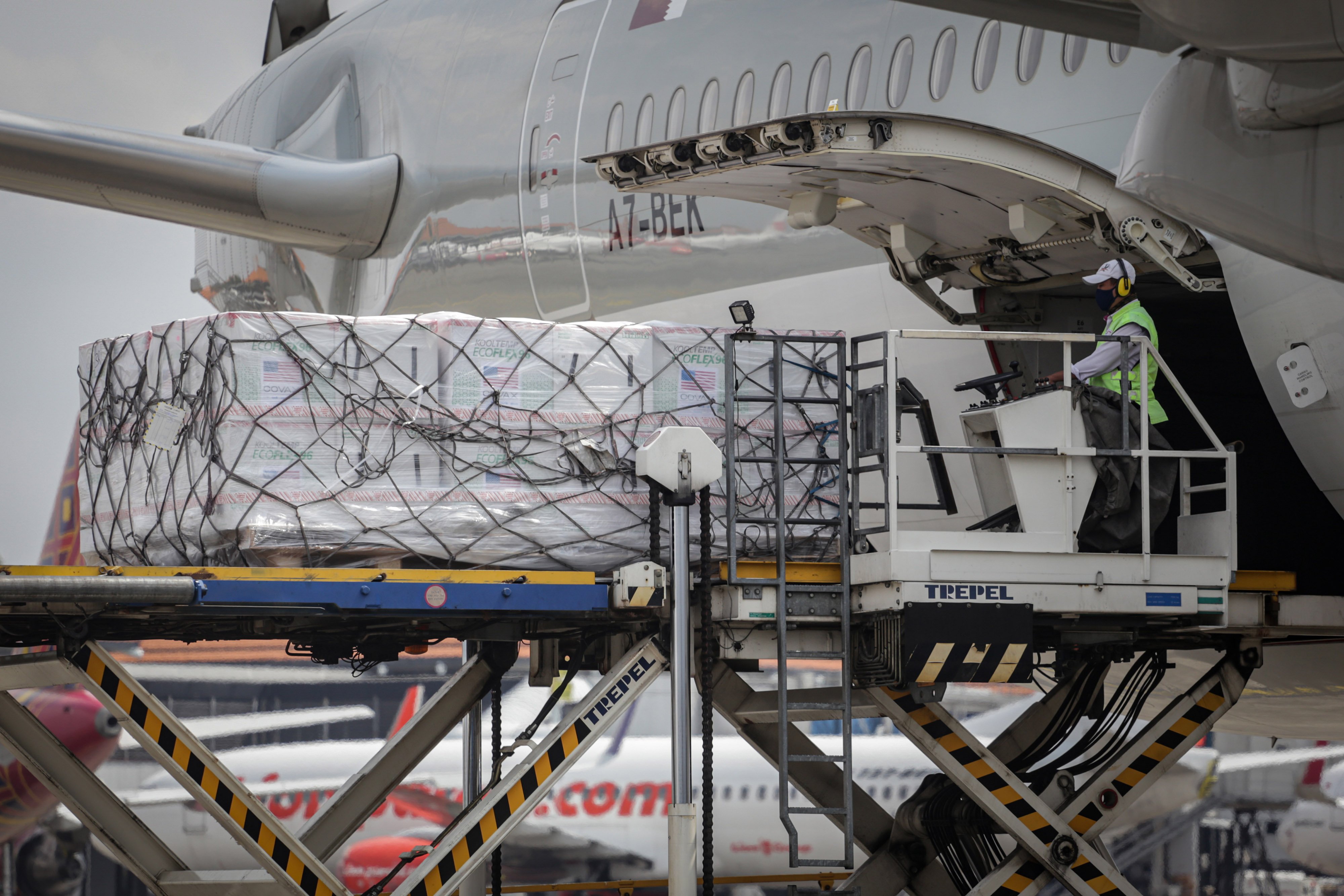 Petugas kargo menurunkan vaksin covid-19 jenis Moderna dari pesawat di Bandara Soekarno-Hatta.