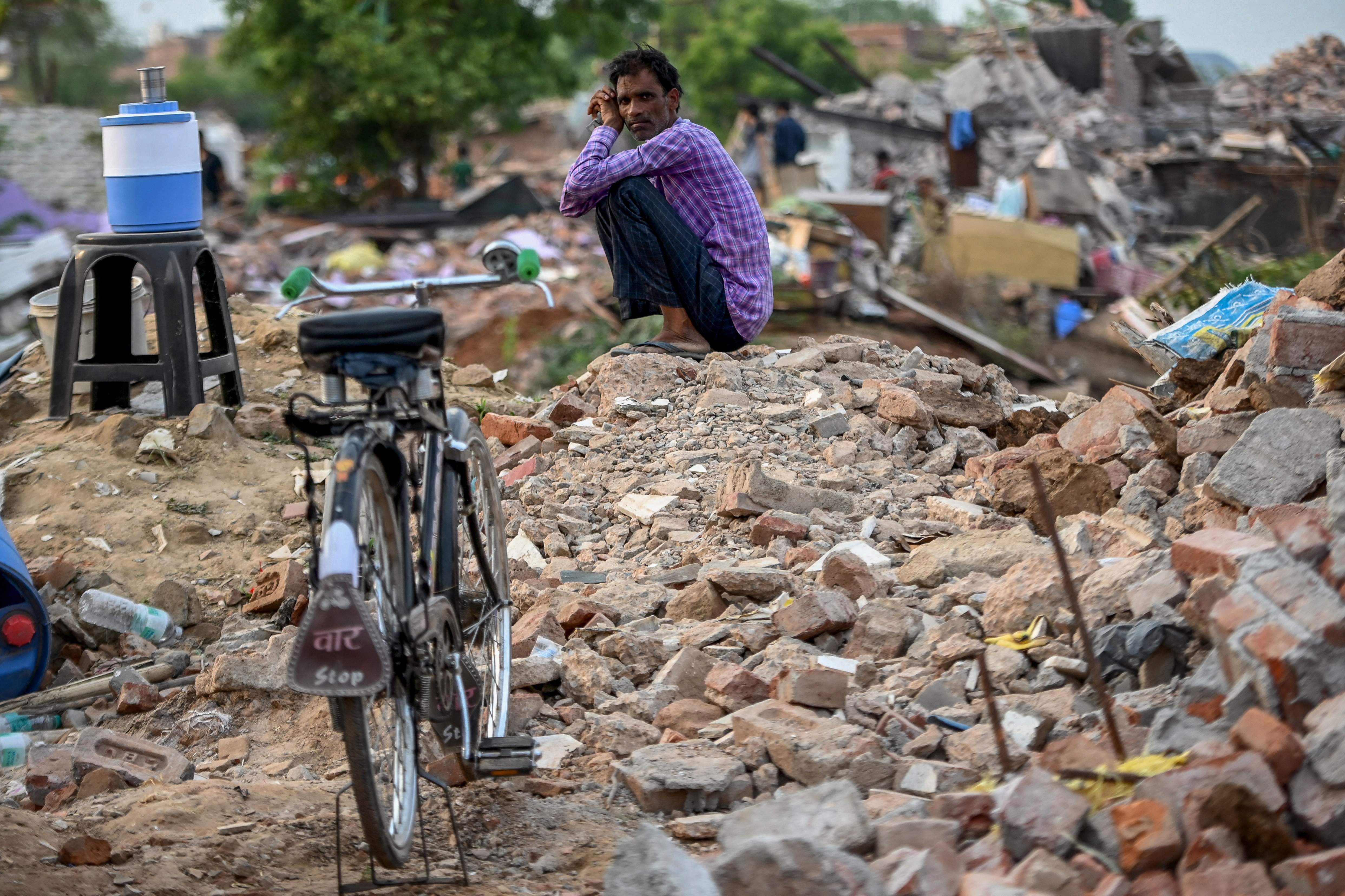 Seorang pria melamun di reruntuhan rumahnya di kawasan hutan Desa Khori, Distri Faridabad, Negara Bagian Haryana, India, Kamis (15/7).