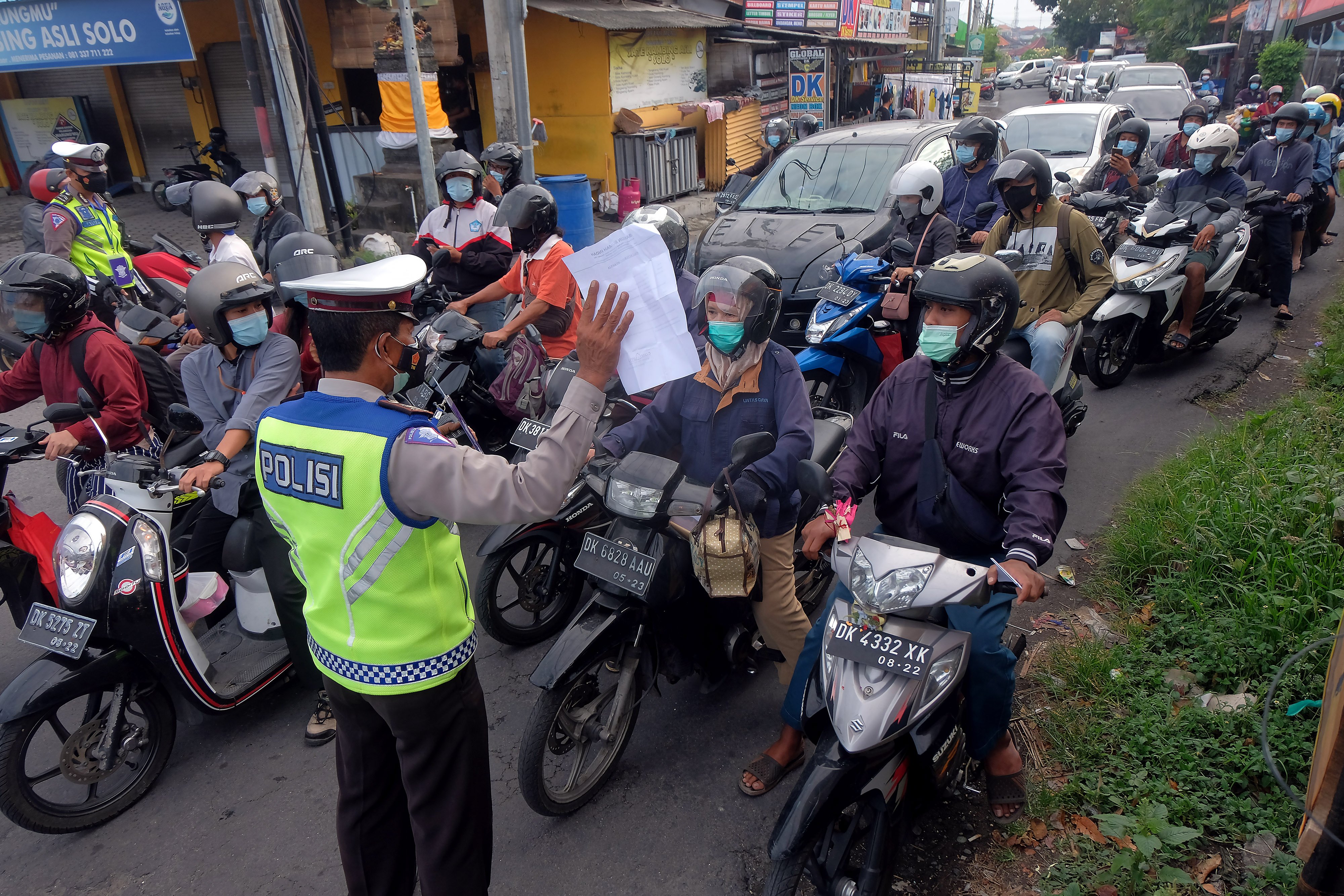 Anggota Polisi meminta warga untuk menunjukkan surat keterangan kerja saat penyekatan PPKM Darurat
