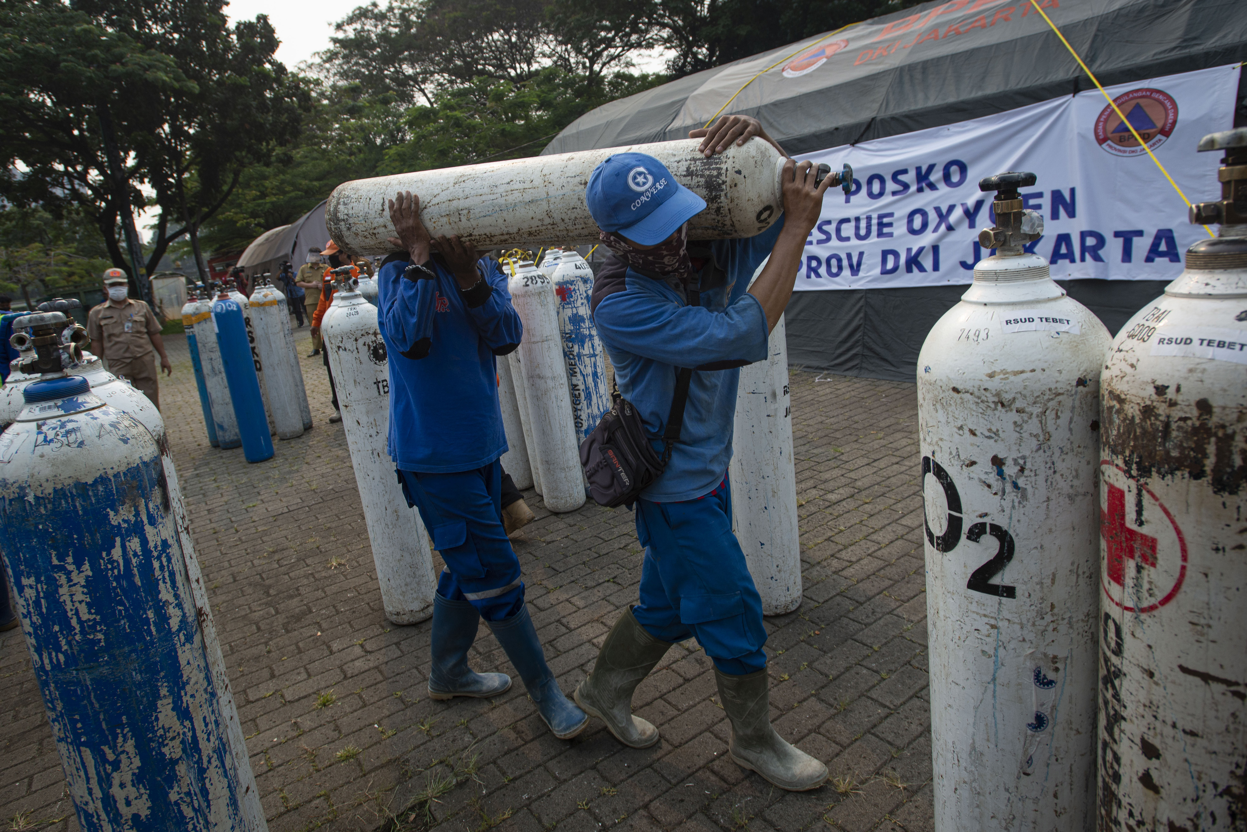 POSKO DARURAT OKSIGEN: Sejumlah petugas mengangkat tabung berisi oksigen di Posko Darurat Oxygen Rescue, kawasan Monas, Jakarta.